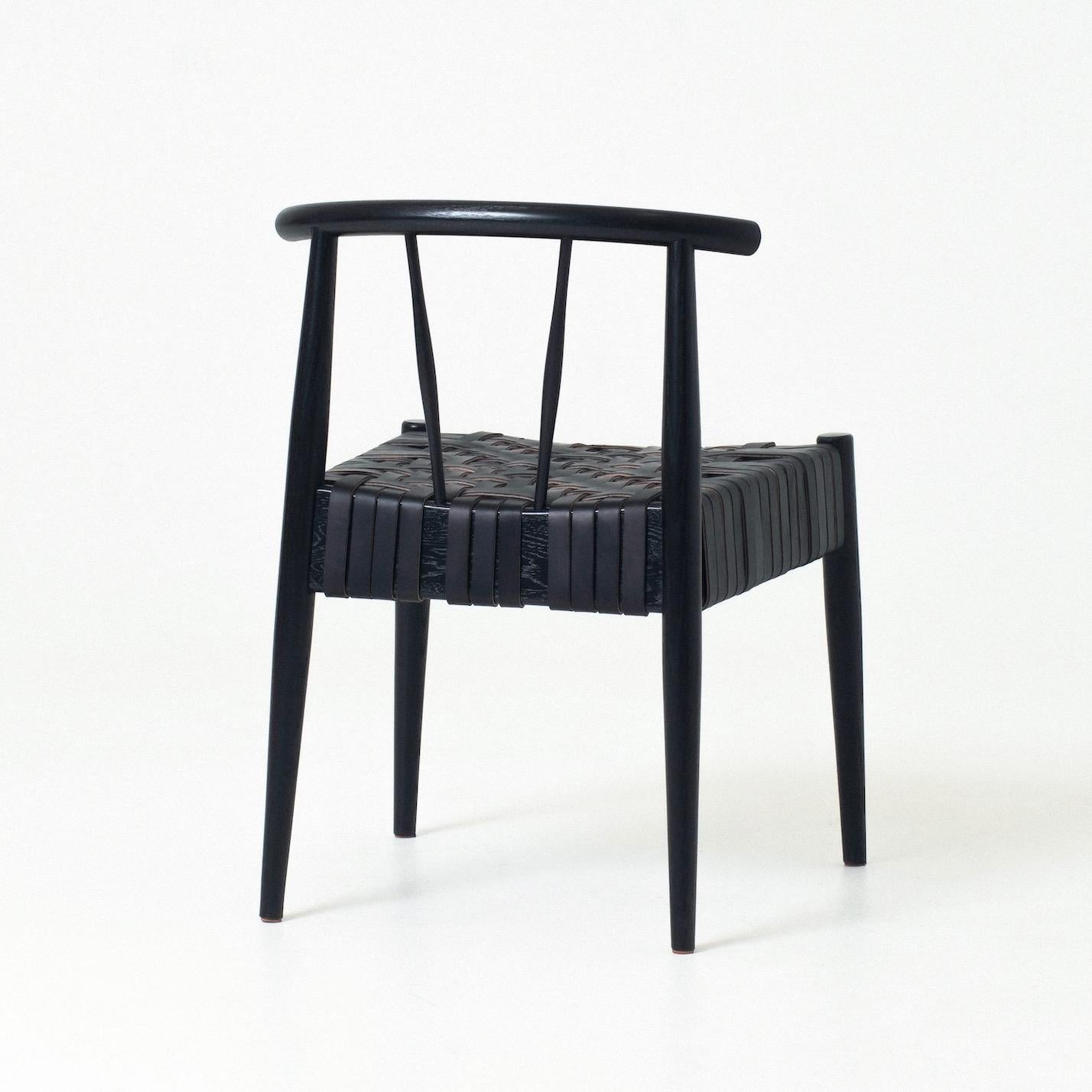 La chaise Neil est une chaise d'appoint moderne dont l'assise est tissée en cuir de bride selon un motif de tissage radial parfois utilisé pour les sièges et les paniers des chaises Shakers traditionnelles. Les pieds tournés de Neil s'évasent dans