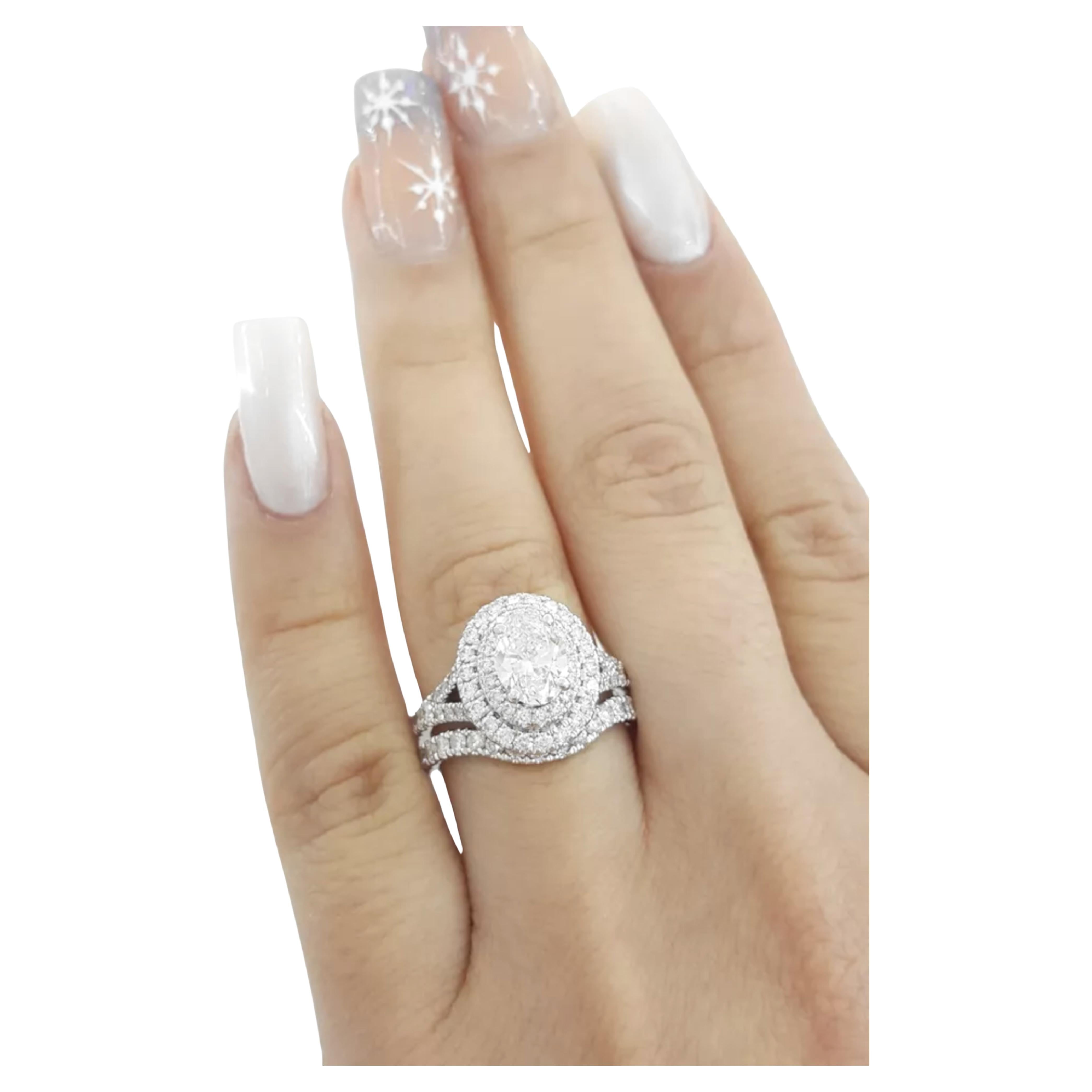  Neil Lane Bridal® Collection engagement ring and wedding band set is a beautiful piece. The engagement ring features a split-shank double halo design with a center stone that is a natural oval brilliant cut diamond weighing approximately 1 ct, with