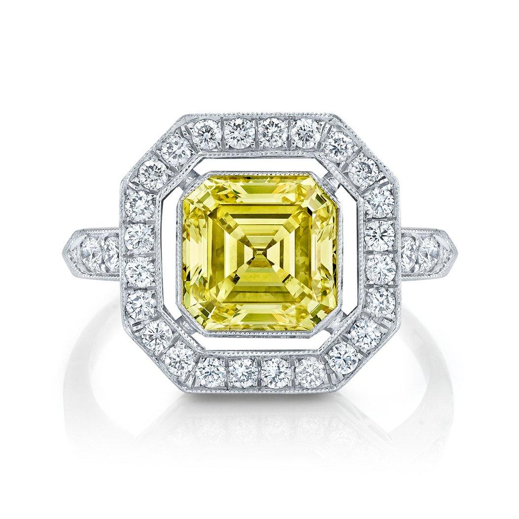 A pleasing glow of sunlight in the form of a square emerald-cut diamond weighing 2.02 cts., mounted within an octagonal shaped diamond set frame, set in platinum with a delightful garland shaped gallery. stating Natural Fancy Intense