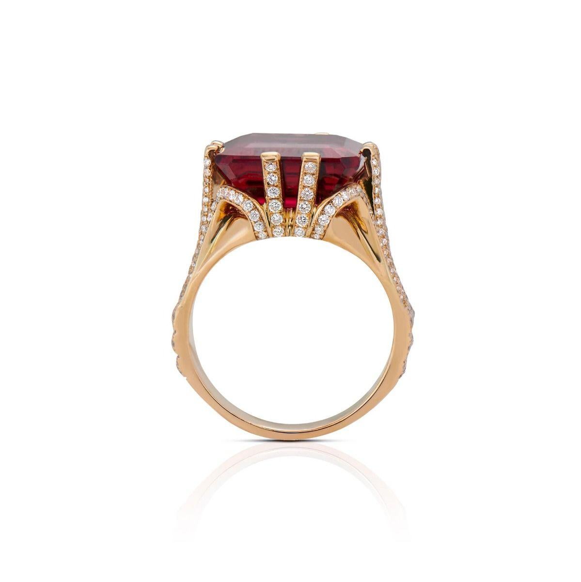 This architectural ring displays an emerald-cut crimson-colored rubellite, weighing 11.48 cts. Handmade in 18k yellow gold, it is set with 345 round-cut diamonds that weigh 1.23 cts. This structural setting raises its centerpiece gemstone in an