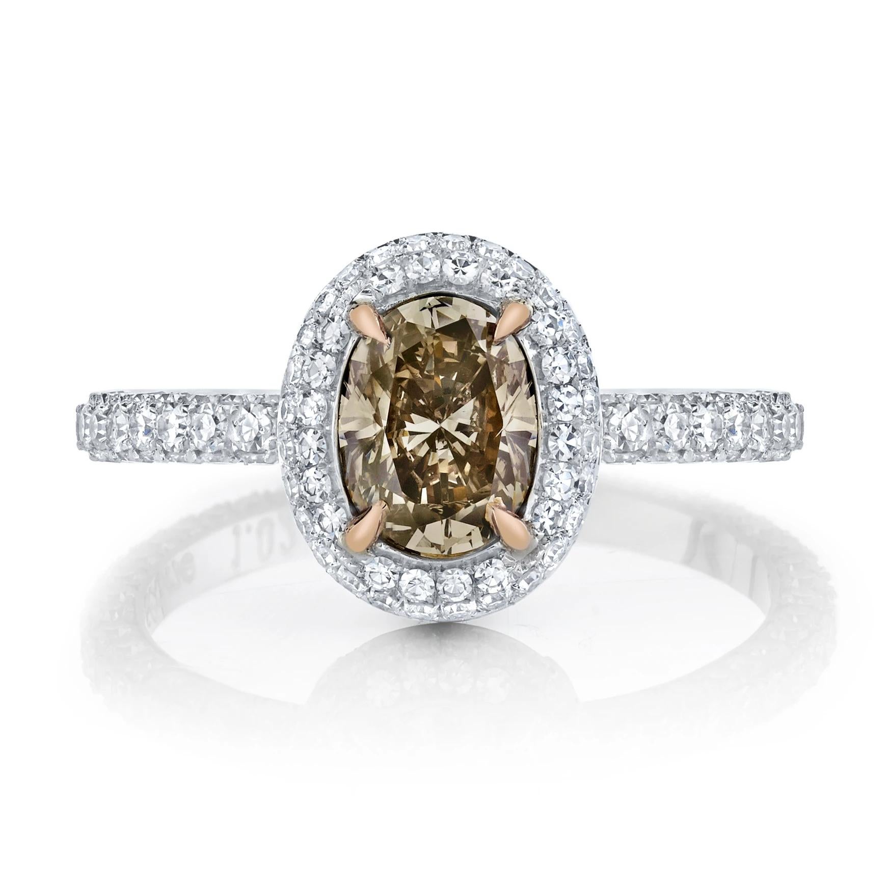 A classic ring with an elegant graduated double halo and three sided band, embellished throughout by one hundred eighty-five single-cut diamonds weighing 1.13 cts., featuring a center oval brilliant-cut Natural Fancy Orange-Brown diamond weighing