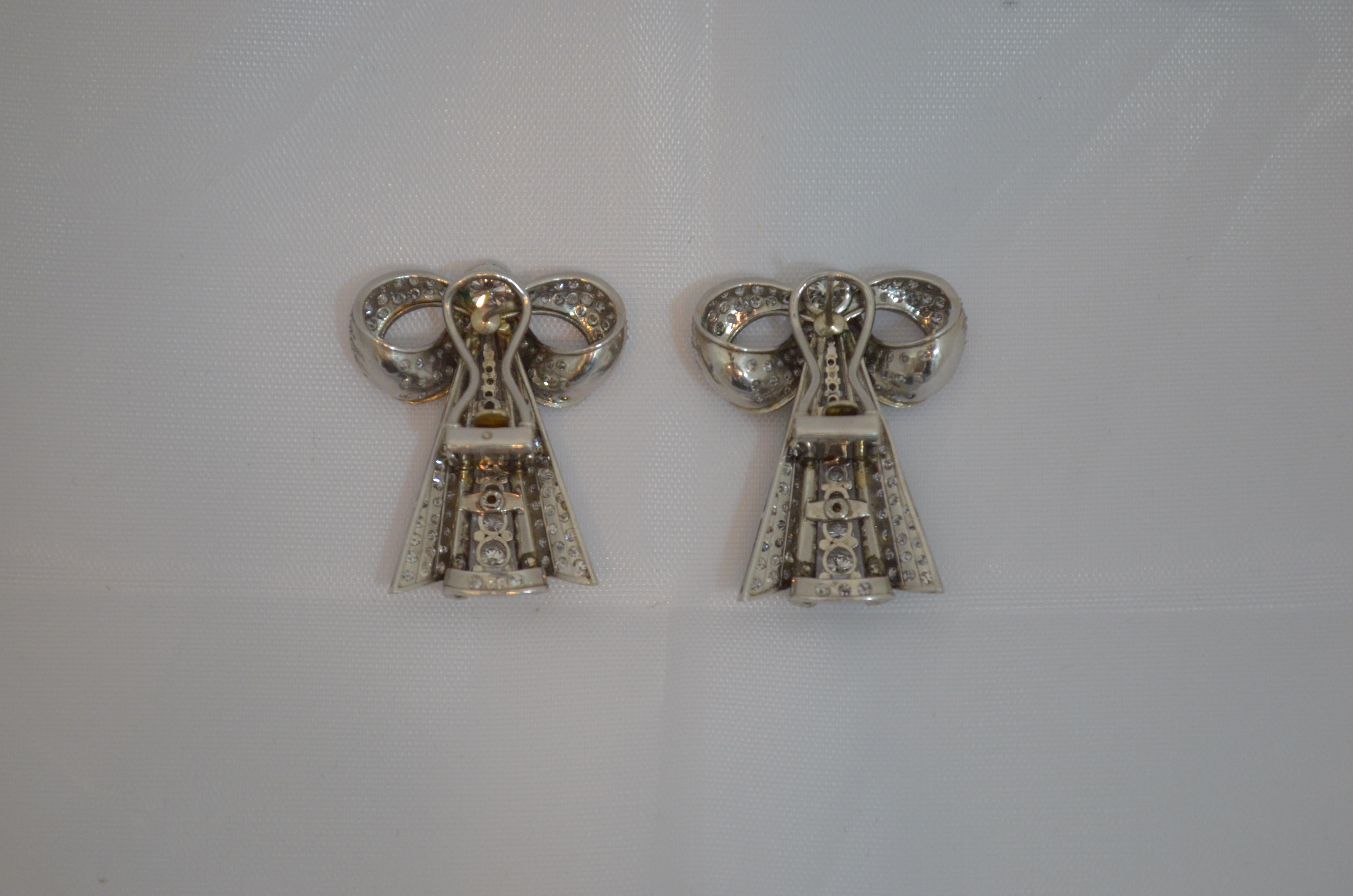 Art Deco/retro style bow earrings. Featured earrings are made from platinum and set with diamonds. The diamonds range from 5.5mm in size (bezel set) to 1mm (set pace style as well as prong set). The large center diamonds are a round brilliant cut