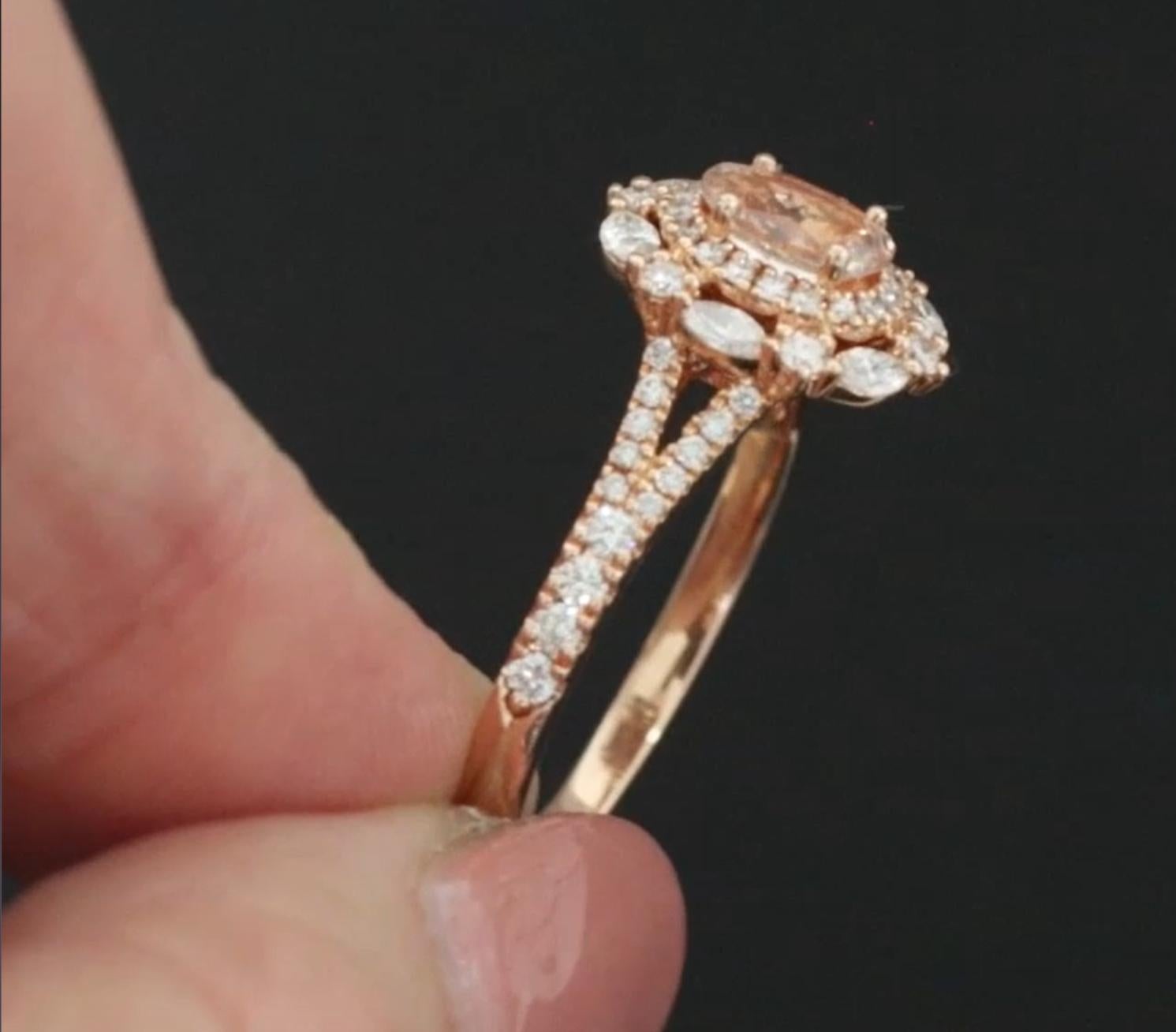 Dieser romantische Verlobungsring wurde vom renommierten Juwelier Neil Lane entworfen und zeigt in der Mitte einen Morganit im Ovalschliff, der in warmen Pfirsich-Rosa-Tönen leuchtet. Umgeben von einem schimmernden Halo aus natürlichen Diamanten und