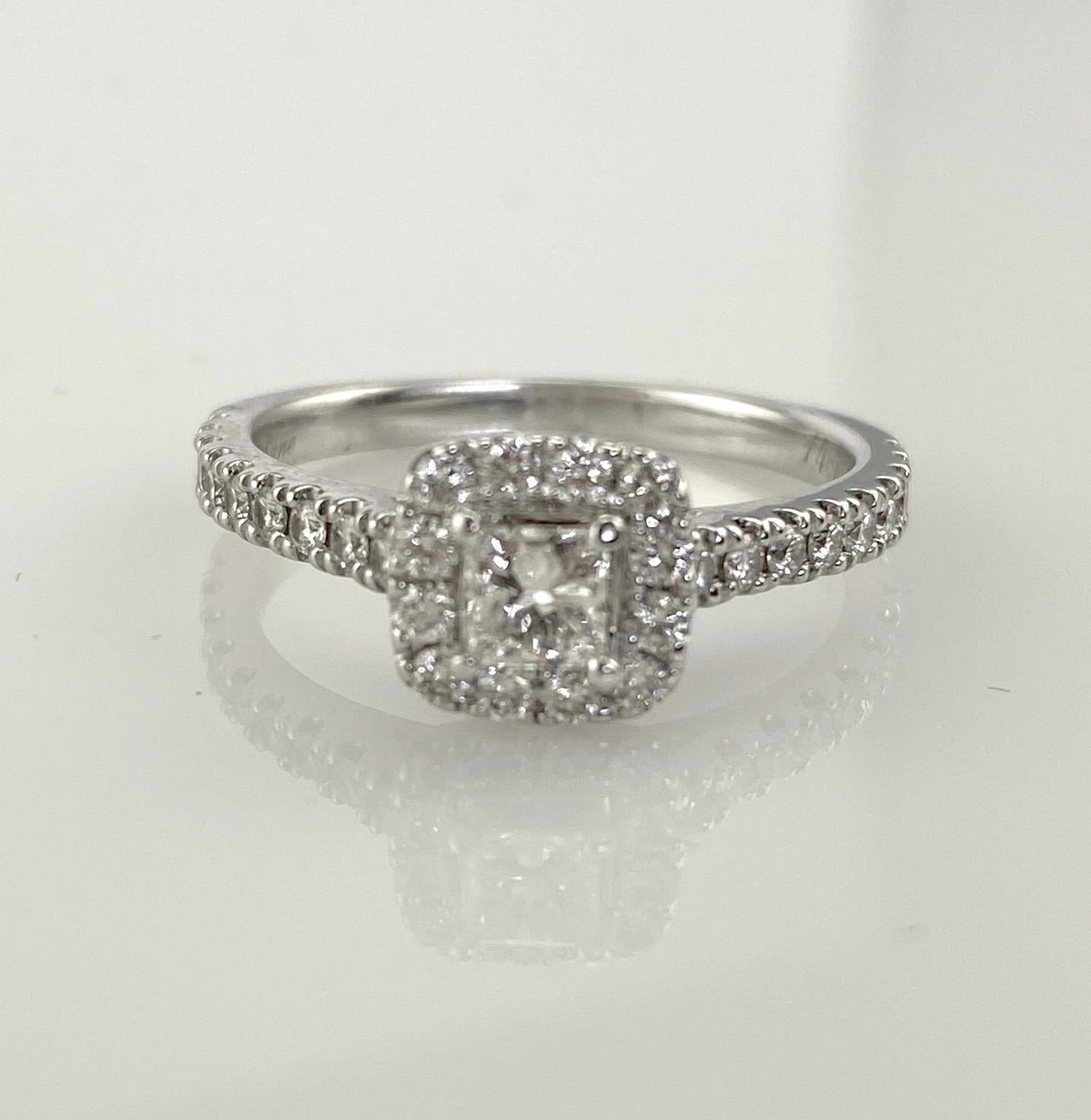 This distinctive women's engagement ring features a dynamic .32 carat princess-cut center stone, haloed by a row of round diamonds. Additional round diamonds line the band, bringing the ring's total diamond weight to 7/8 carat. I1; I quality. The
