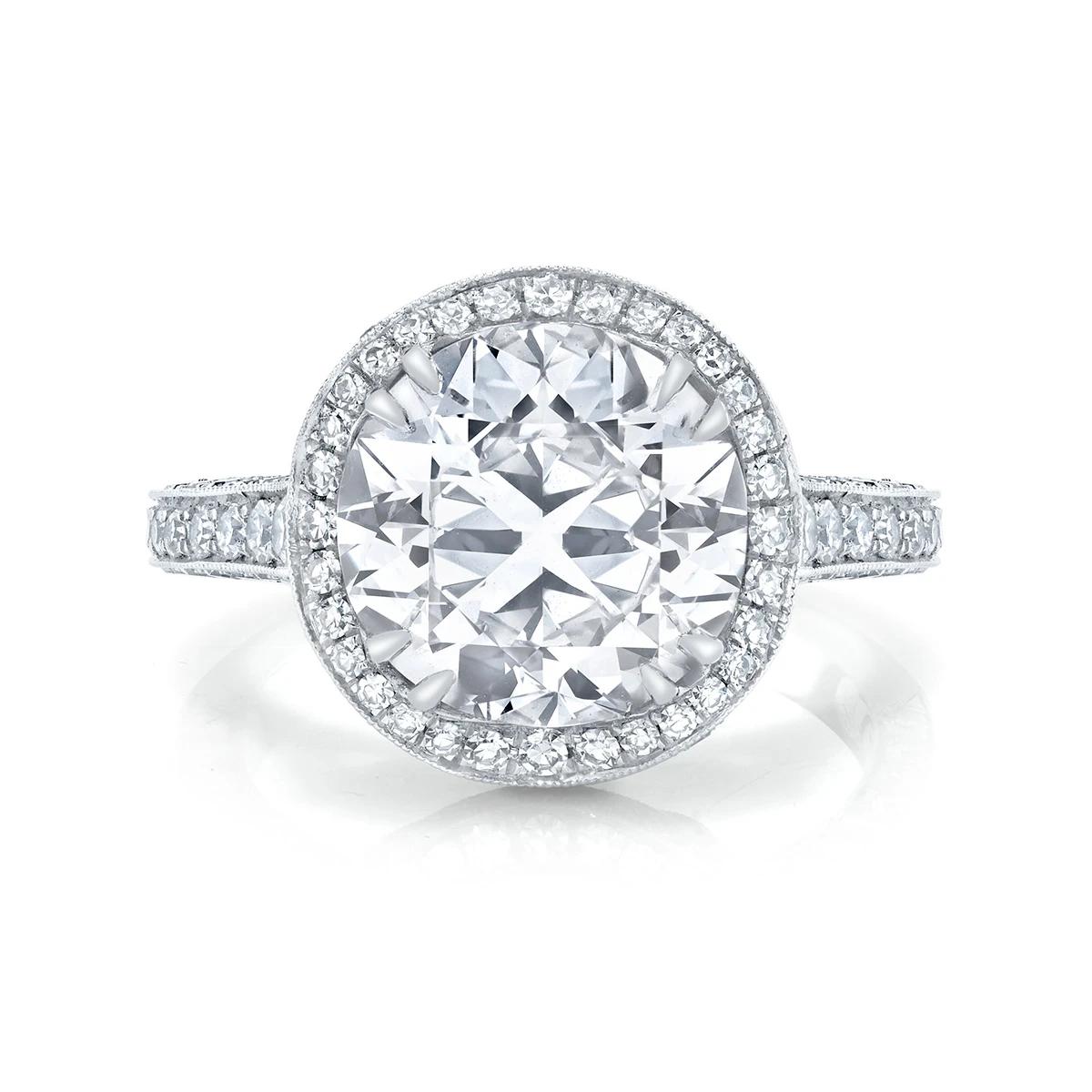 A sumptuous pairing of an impressive round brilliant-cut diamond weighing 4.06 cts., and a regal handmade platinum ring, accented by one hundred forty-two round-cut diamonds composing an elegant undulating border and ornate gallery.

Center Stone