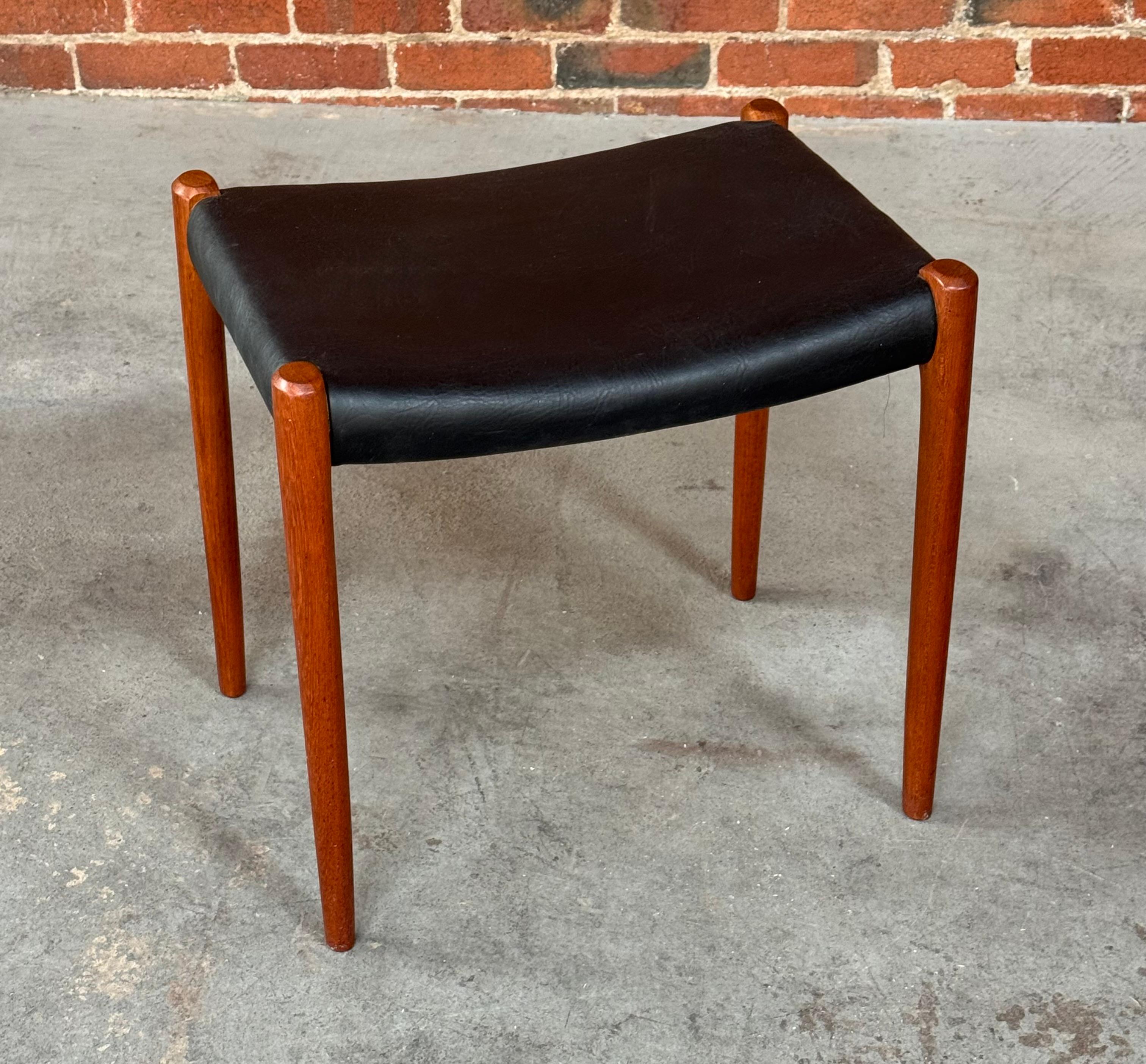 Tabouret / ottoman en teck et cuir du designer danois Niels O Moller (1920-1982) pour sa société JL Mollers Mobelfabrik du Danemark. Pieds fuselés en teck et rembourrage en cuir noir, estampillé sur le dessous.