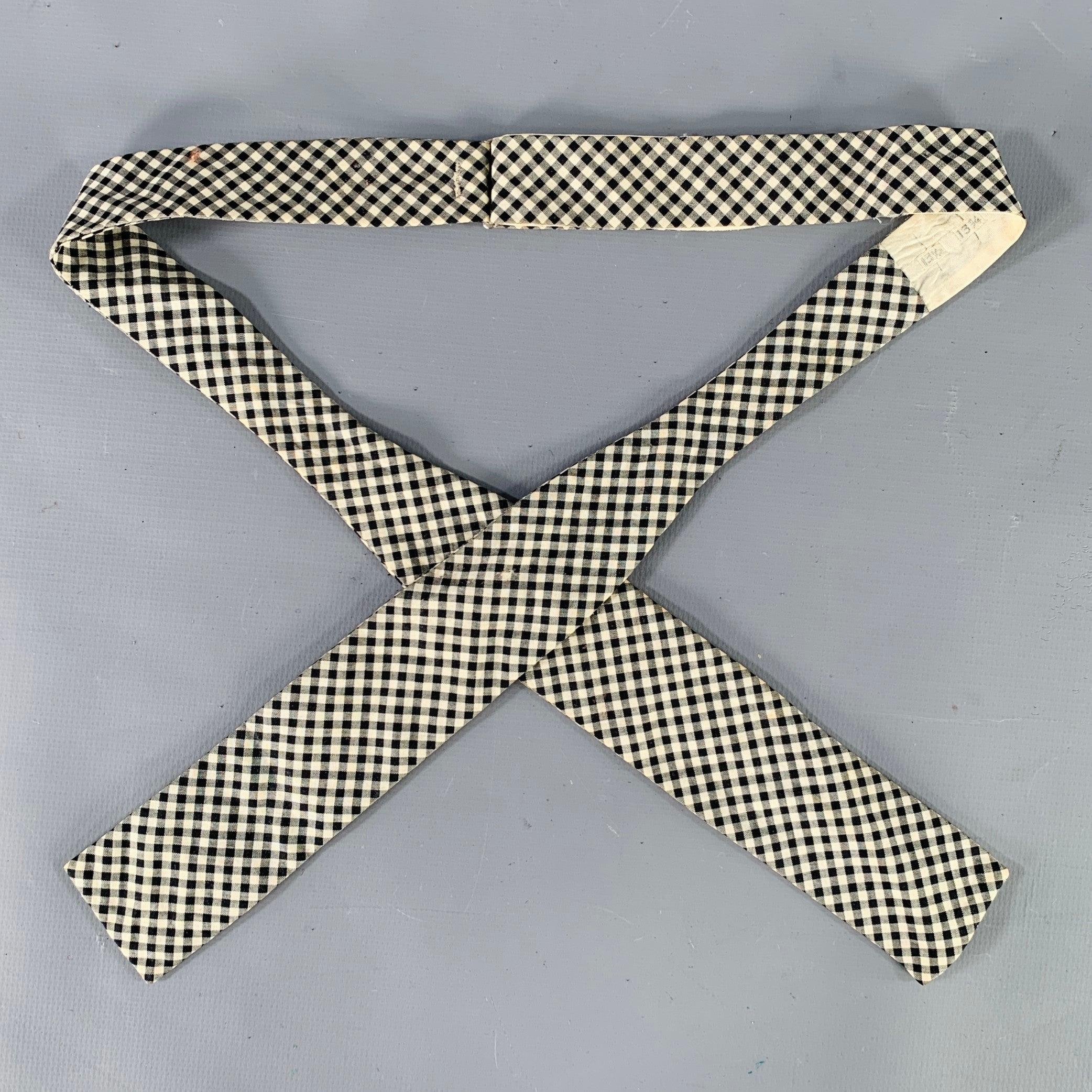 Vintage NEIMAN MARCUS bow tie
in a black and white cotton featuring a narrow batwing style, gingham pattern, and adjustable fit. Made in USA.Good Pre-Owned Condition. Signs of wear consistent with vintage condition. 

Measurements: 
  Width: 1.5