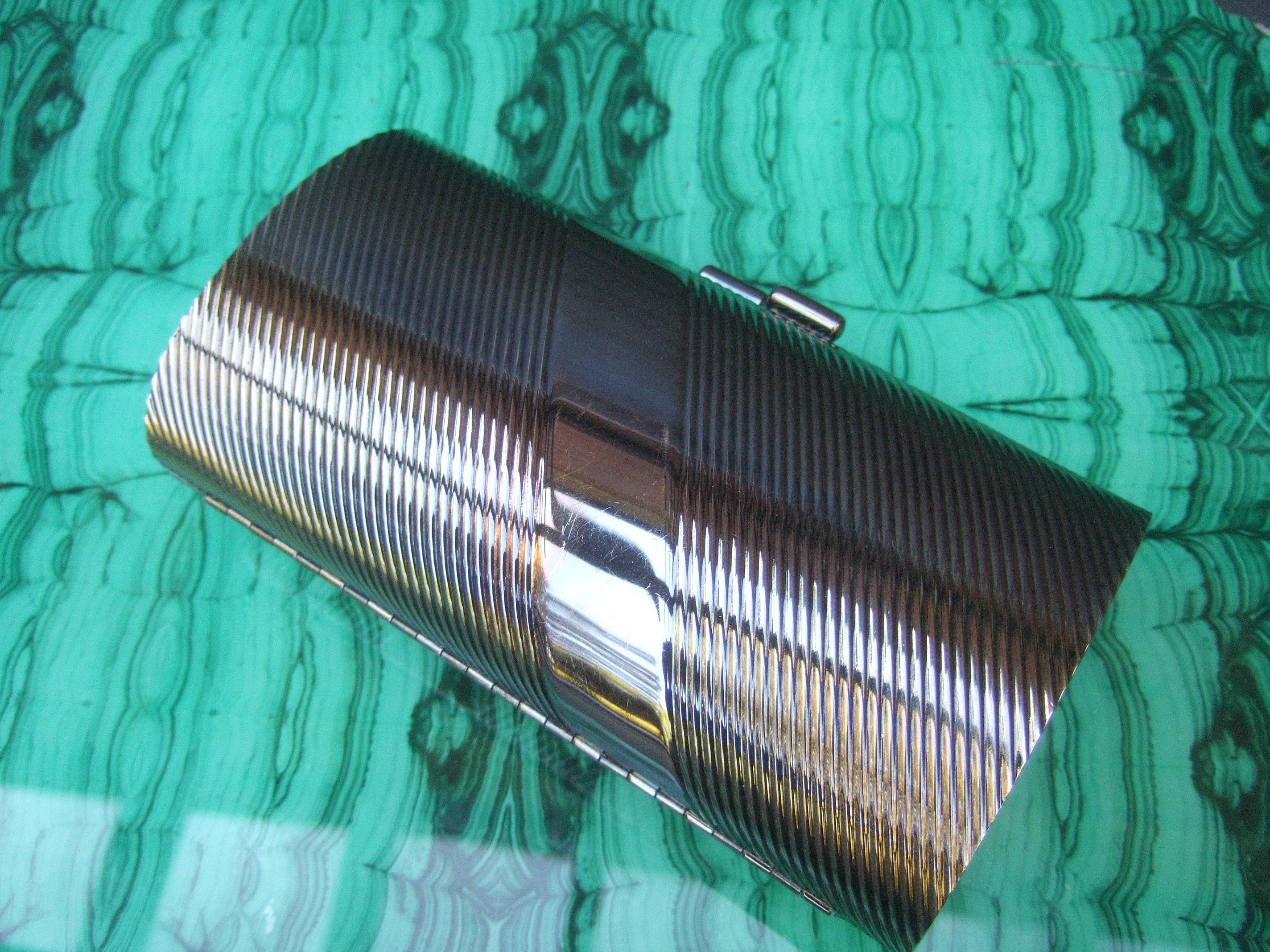 Neiman Marcus brünierte silberne Minaudiere-Abendtasche, 1980er Jahre

Die schlichte Abendtasche hat eine gewollte, gedunkelte silberne Metallpatina. Entworfen mit gerillten vertikalen Bändern in einer diagonalen Schräglage. Im Gegensatz dazu ist
