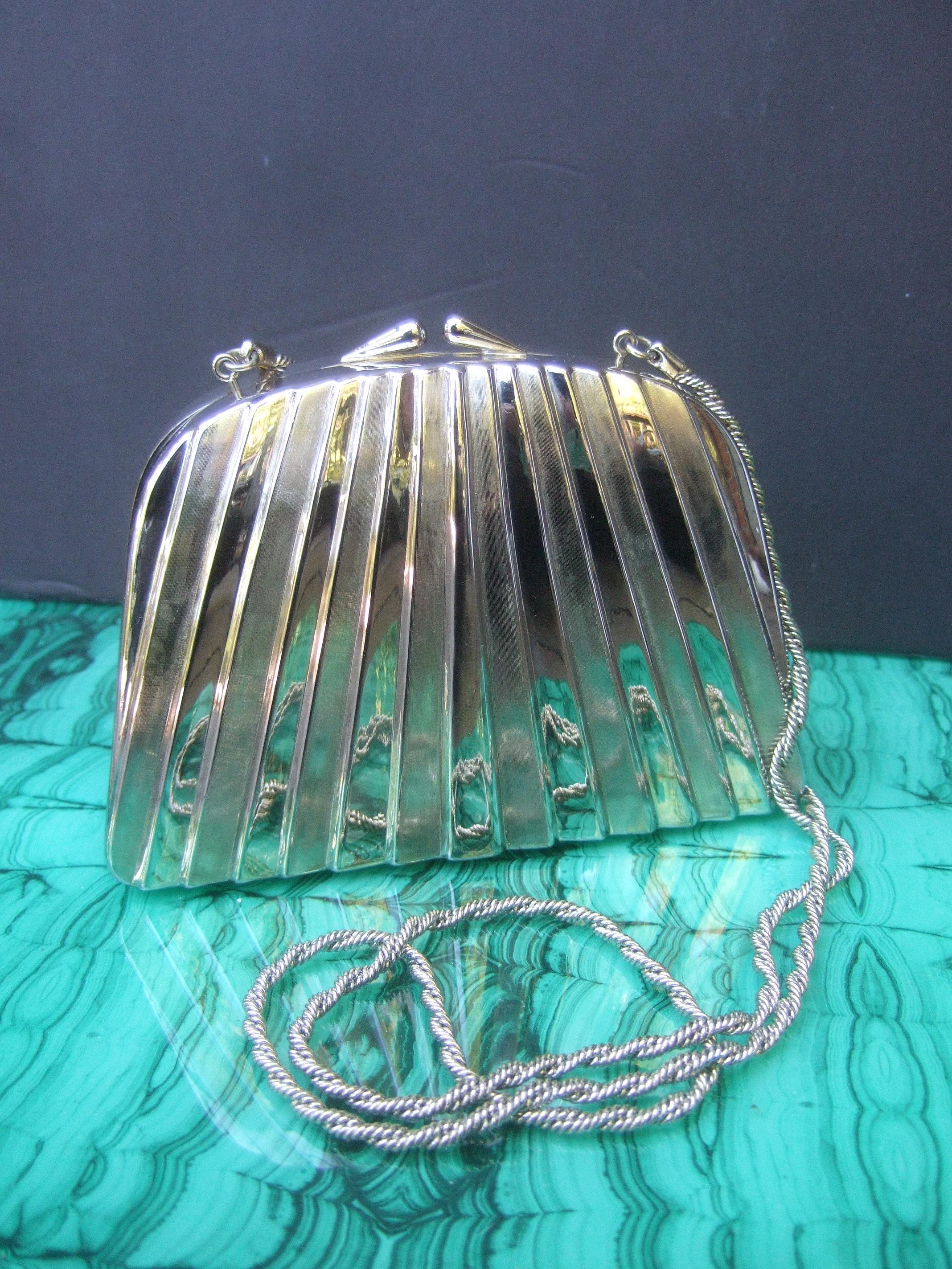 Neiman Marcus Italian silver metal minaudiere evening bag c 1970s
The elegant silver metal evening bag is designed with impressed vertical linear bands that alternate from shiny polished silver metal; juxtaposed with brushed satin tone vertical
