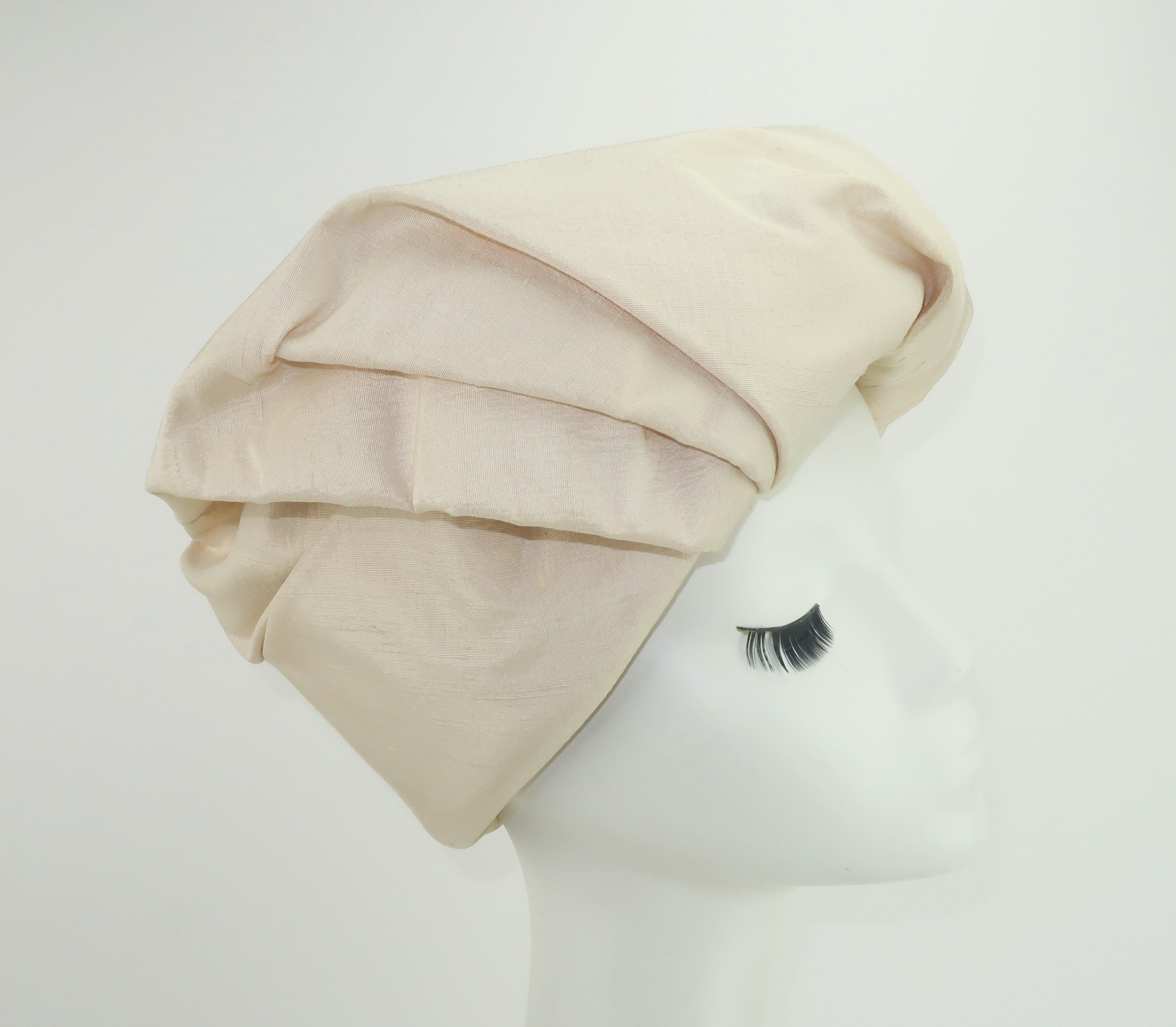 C.1960 Neiman Marcus 'Made to Order' silk shantung hat in an ivory or candlelight white shade.  The hat has a chic turban style design with effortless folds that create a stylish topper.  It takes on a casual look when worn backwards as shown in