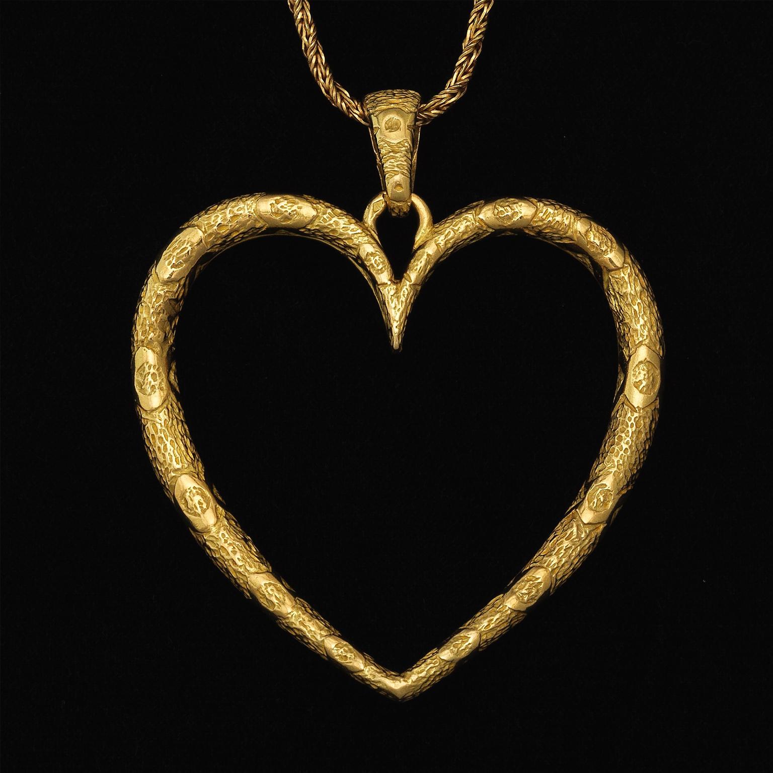 An 18 carat yellow gold braided chain with a huge oversized heart pendant with large bail, hand chased textured finish; marked on the clasp and signed on the pendant: 5616 N.M. (For Neiman Marcus), Made in France, circa 1970.

weight: 37.2