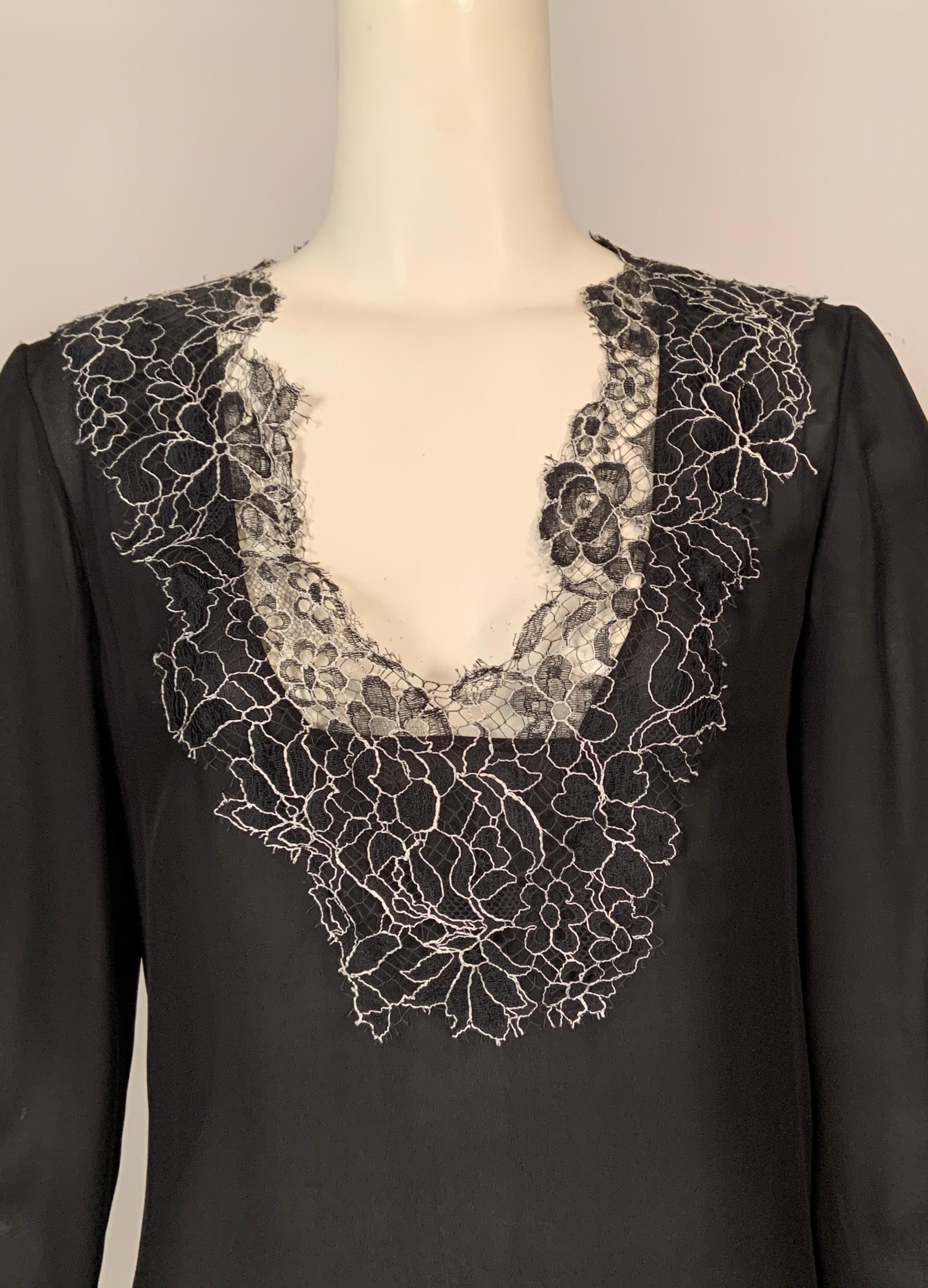 Two layers of semi sheer black silk chiffon are trimmed with a deep border of black and white floral lace, so delicate it resembles a spider web. The blouse was retailed by Neiman Marcus and still bears the original tags. There is a left side zipper
