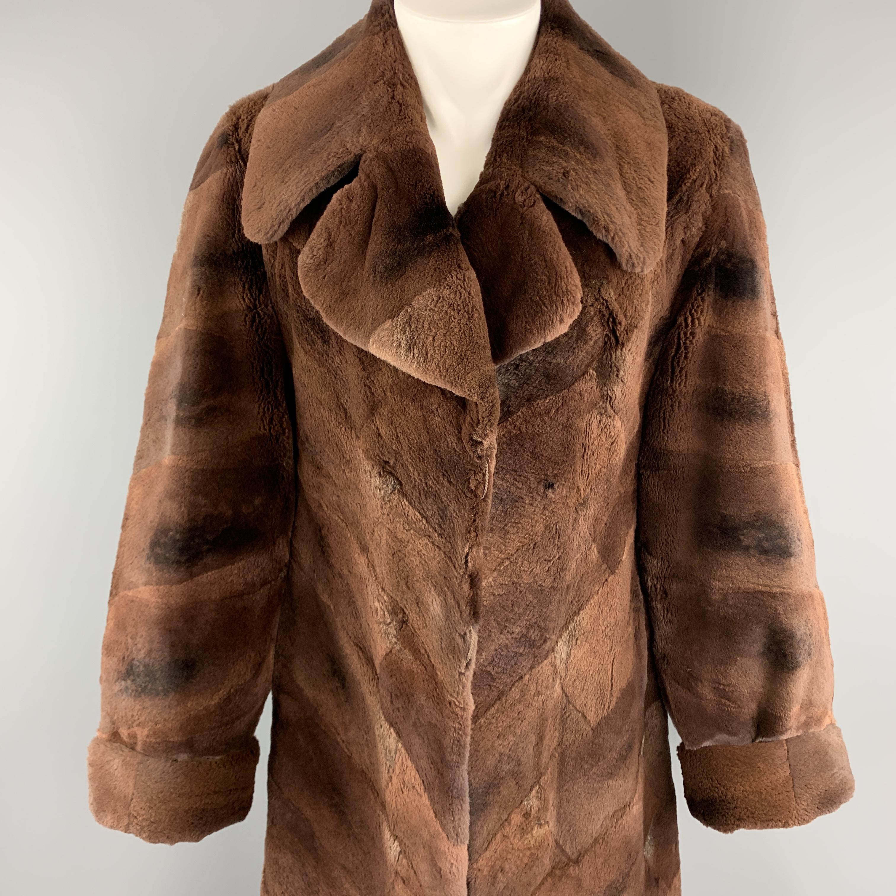 Vintage ZUKI for NEIMAN MARCUS fur coat comes in geometrical placed dyed muskrat fur with a pointed collar lapel, cuffed sleeves, slit pockets, and printed liner. Buttons have been removed. As-is. Made in Canada. 

Very Good Pre-Owned