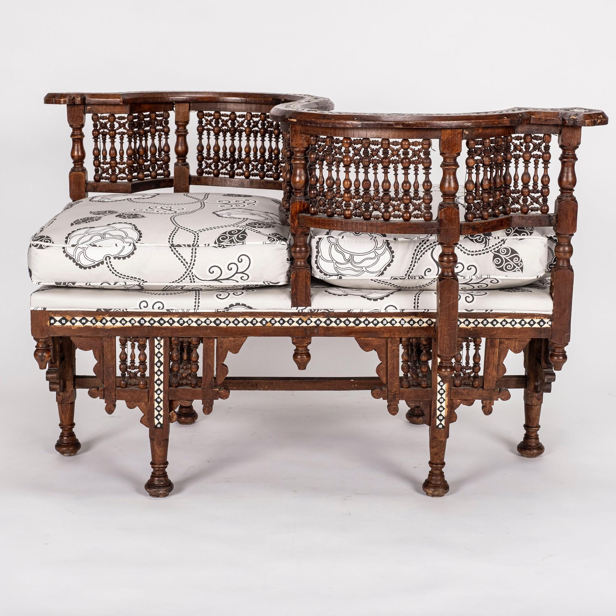 19th century Moroccan tête-à-tête newly upholstered in a stylish Neisha Crosland Silver White Queen Fruit chintz by Schumacher. This charming frame features fretwork, spindles and mother of pearl inlay.

Condition: Sturdy hardwood Frame in good to