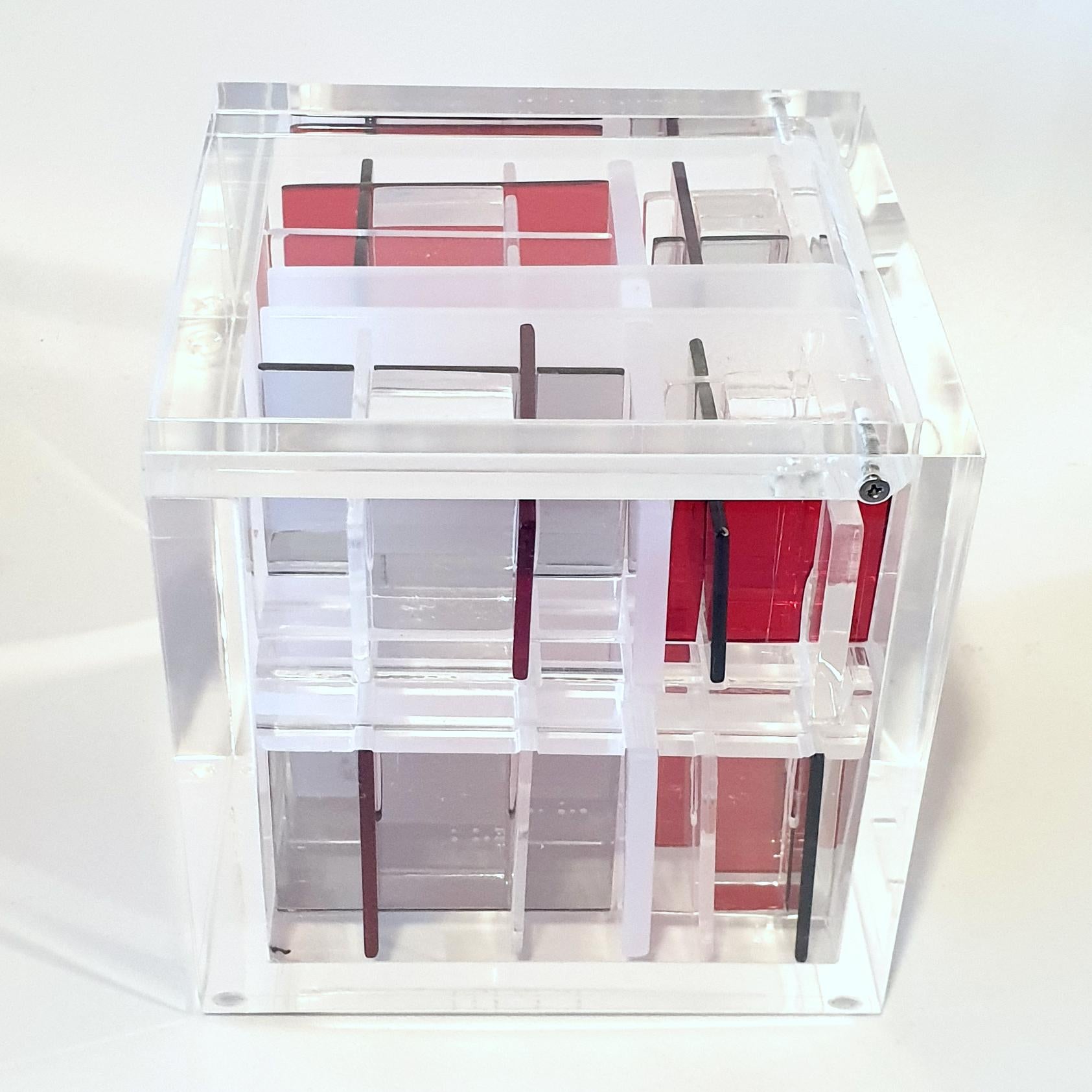 System Red-Grey est une sculpture cubique contemporaine unique de petite taille réalisée par le célèbre couple d'artistes néerlandais Nel Haringa et Fred Olijve, dans laquelle ils explorent les effets de compositions opposées en rouge, gris et