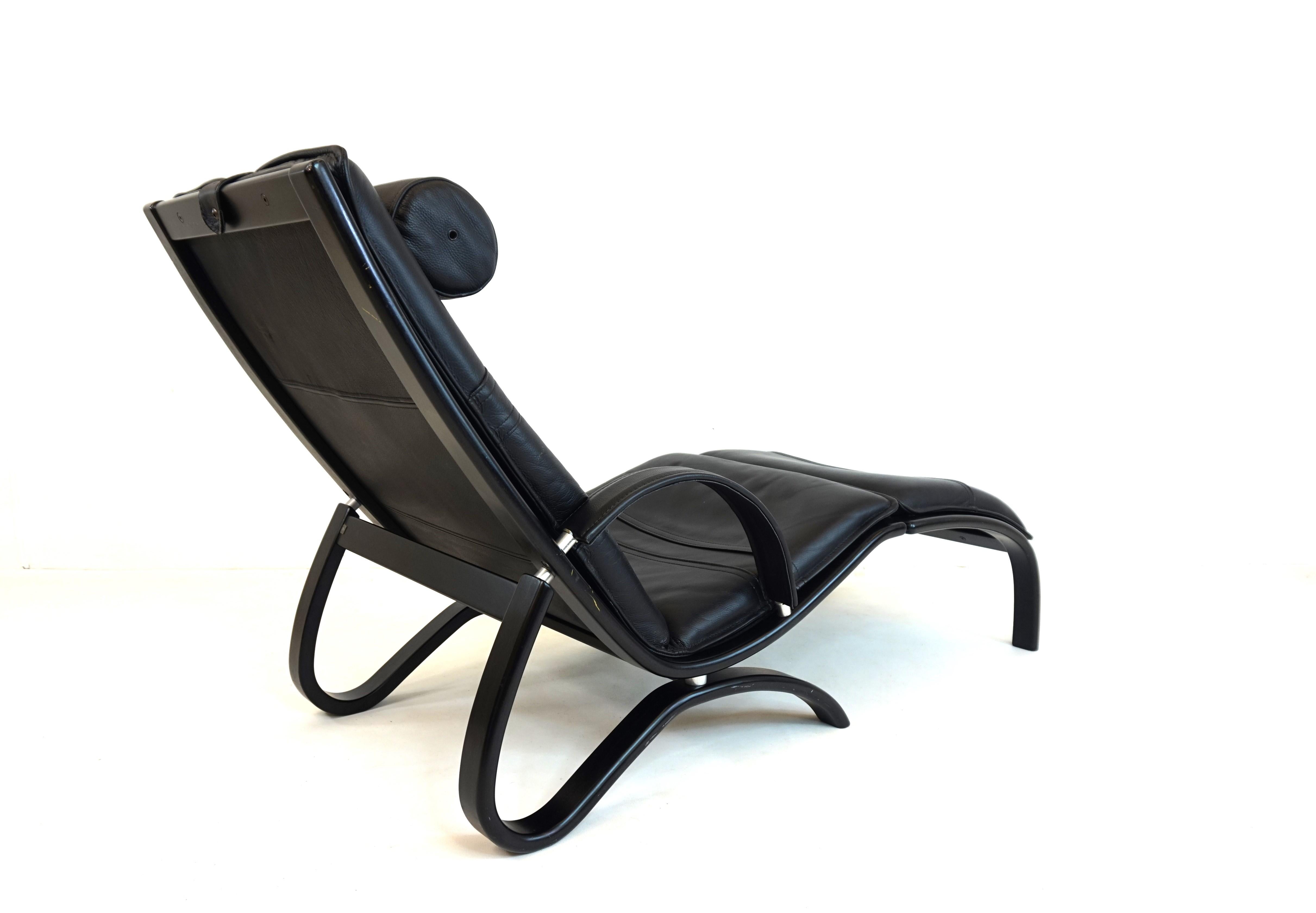 An exceptional leather armchair from Nelo, made of black leather with a semi-integrated ottoman. This armchair can be quickly converted into a reclining armchair using the attached ottoman. The extraordinary design once again shows the innovative