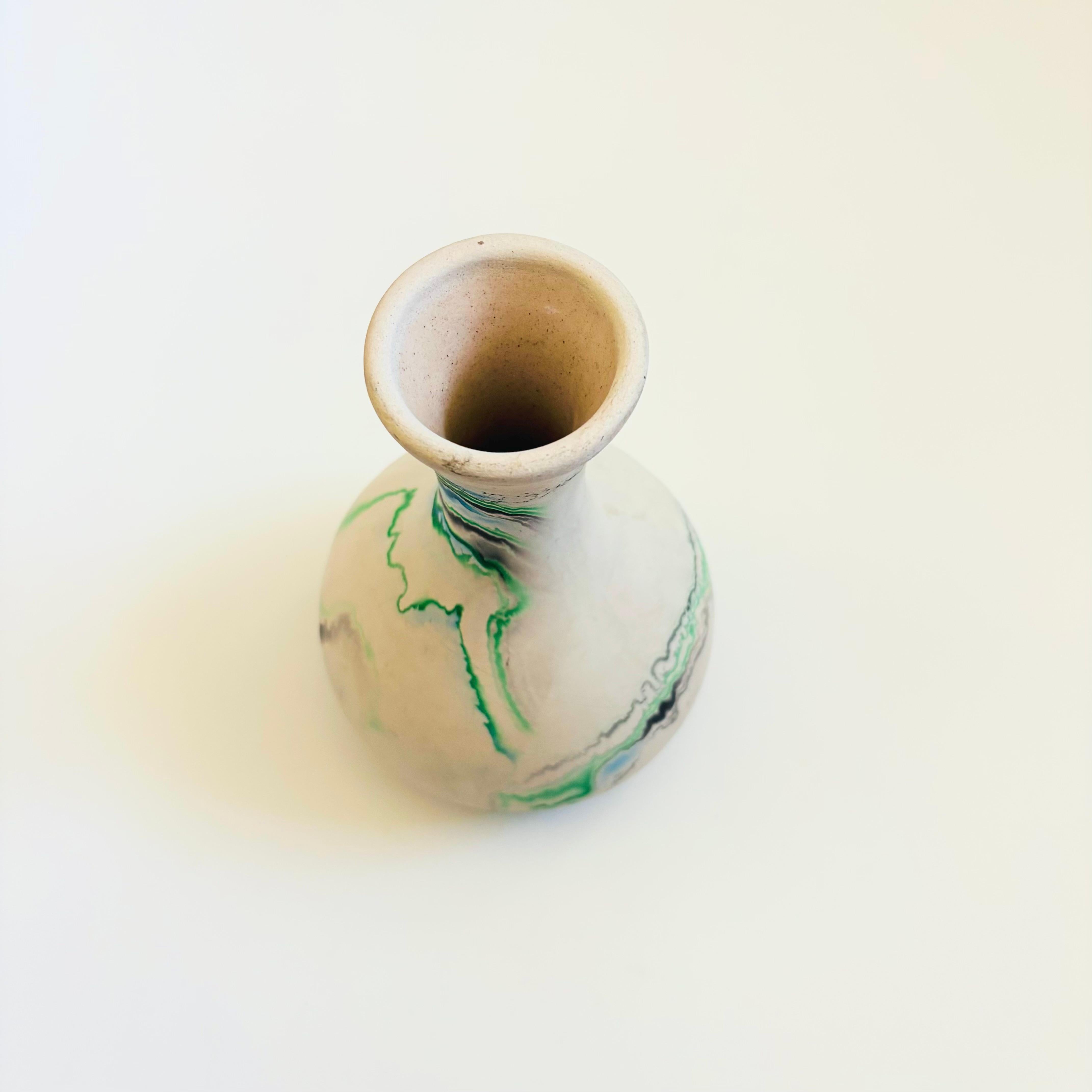 Un vaso vintage in ceramica nemadji con un bellissimo motivo organico di volute verdi su uno sfondo bianco chiaro. Esterno smaltato opaco, interno smaltato. Marcato sulla base.

