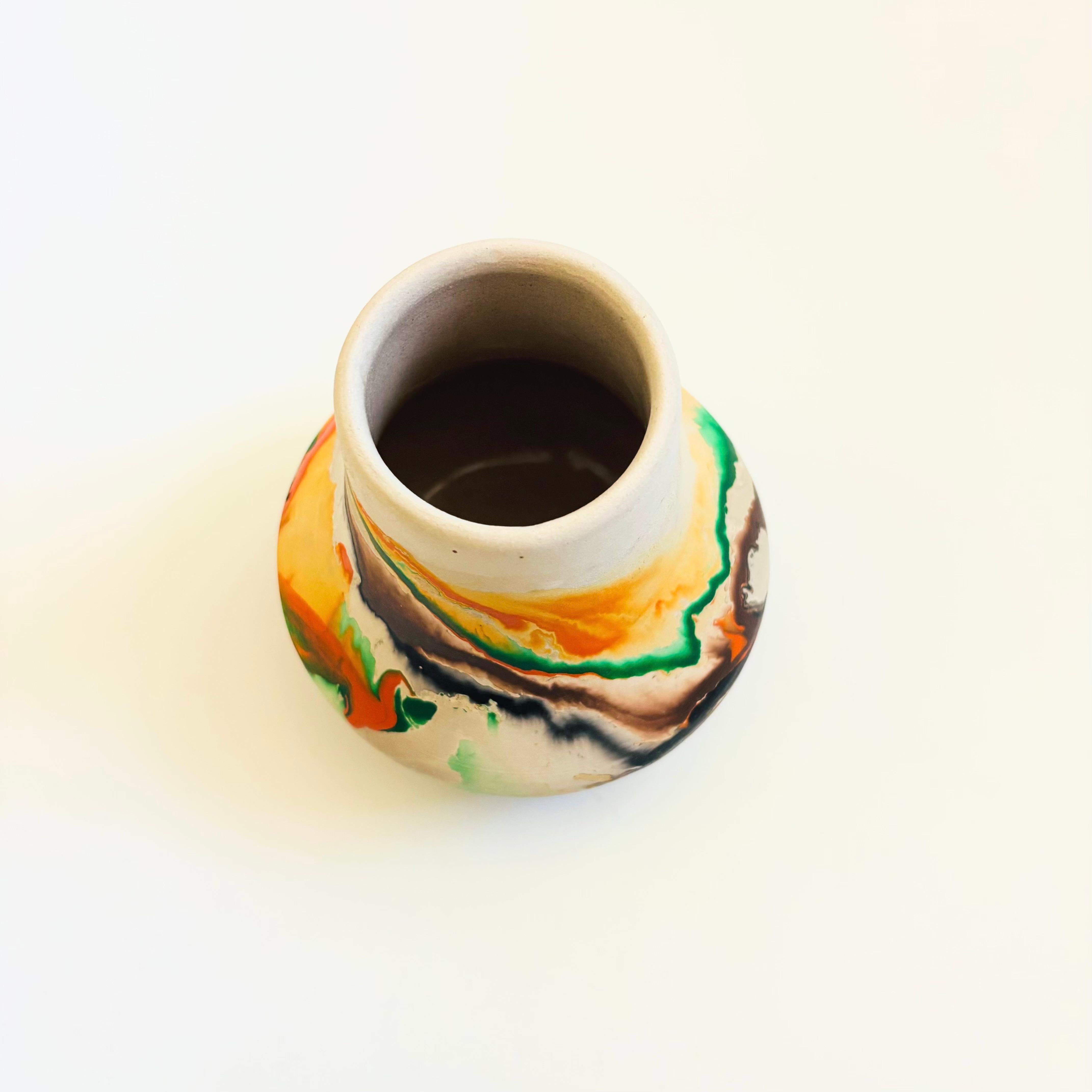 Un vaso vintage in ceramica nemadji con un bellissimo motivo organico di volute multicolori su uno sfondo bianco sporco. Esterno smaltato opaco, interno smaltato. Marcato sulla base.

