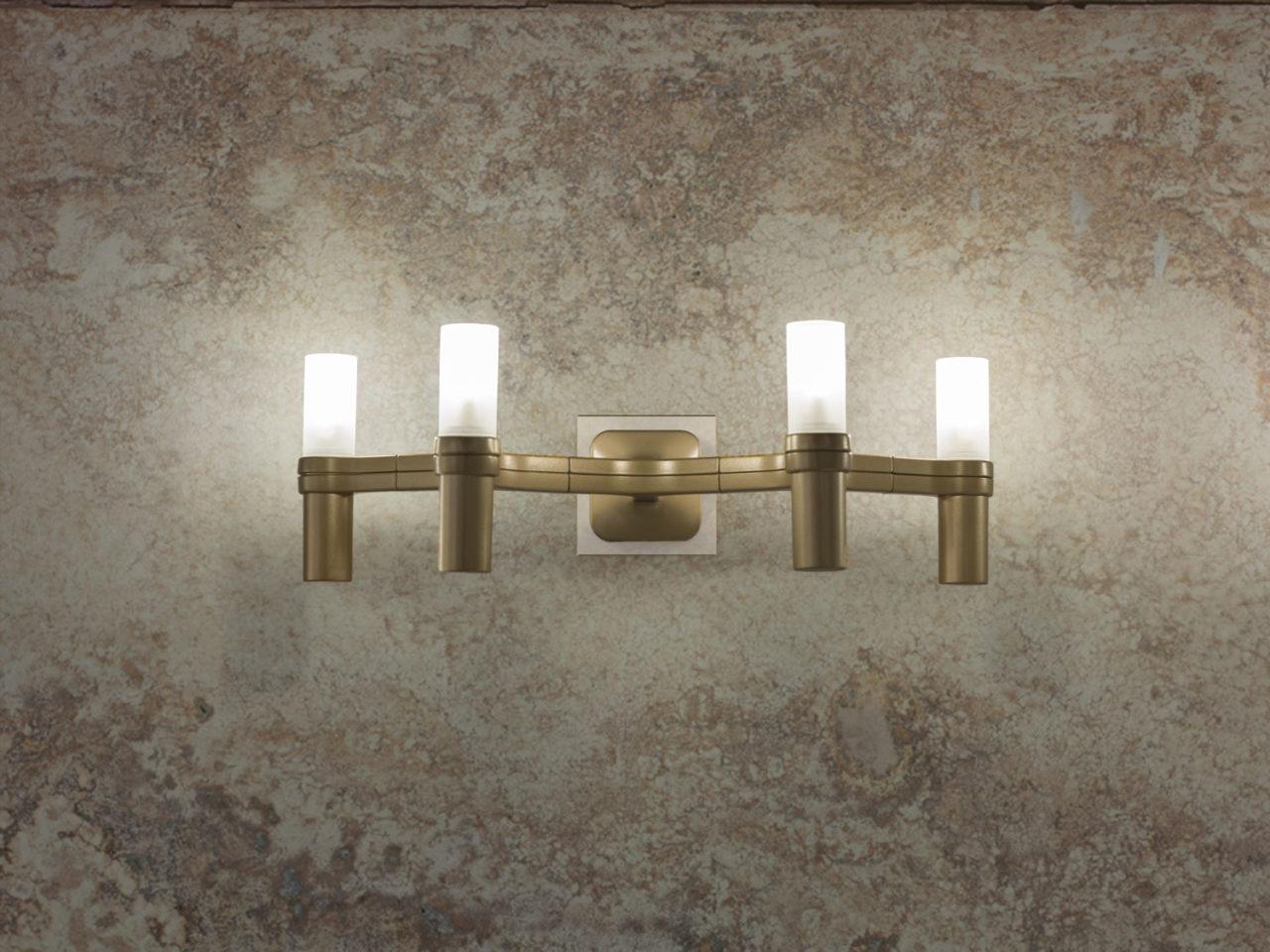 Lámparas de pared, con estructura modular de aluminio fundido a presión y difusores de vidrio arenado. Estructura de aluminio y disponible en distintas versiones: pulido a mano brillante, chapado en oro, o pintado en blanco mate, negro mate u