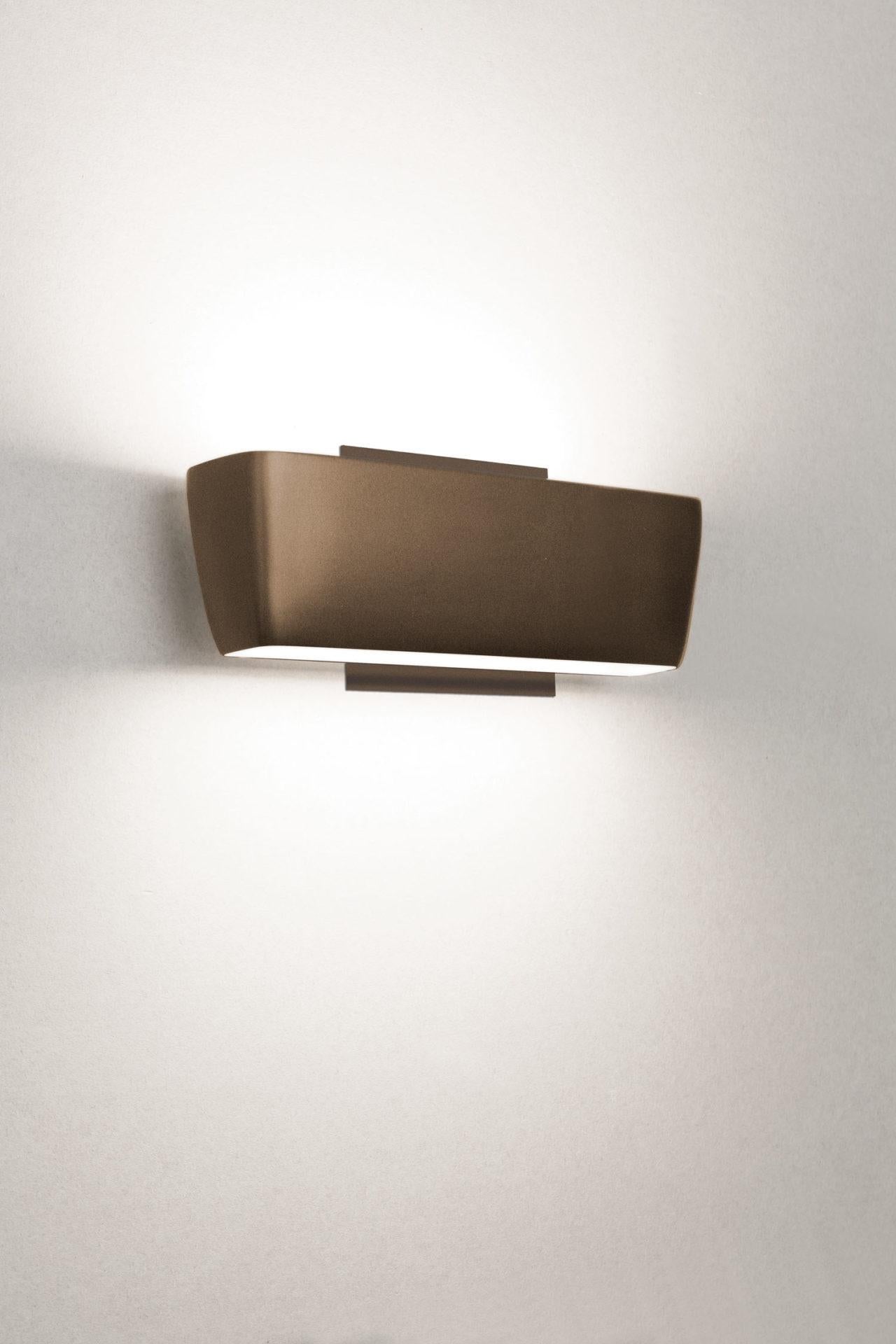 Lámpara de pared, doble salida para una luz de inundación ascendente y descendente. Aluminio fundido a presión, con difusor de Pyrex arenado o metacrilato opalino para la versión LED. Estructura pintada en blanco mate, moka, champán o antracita.