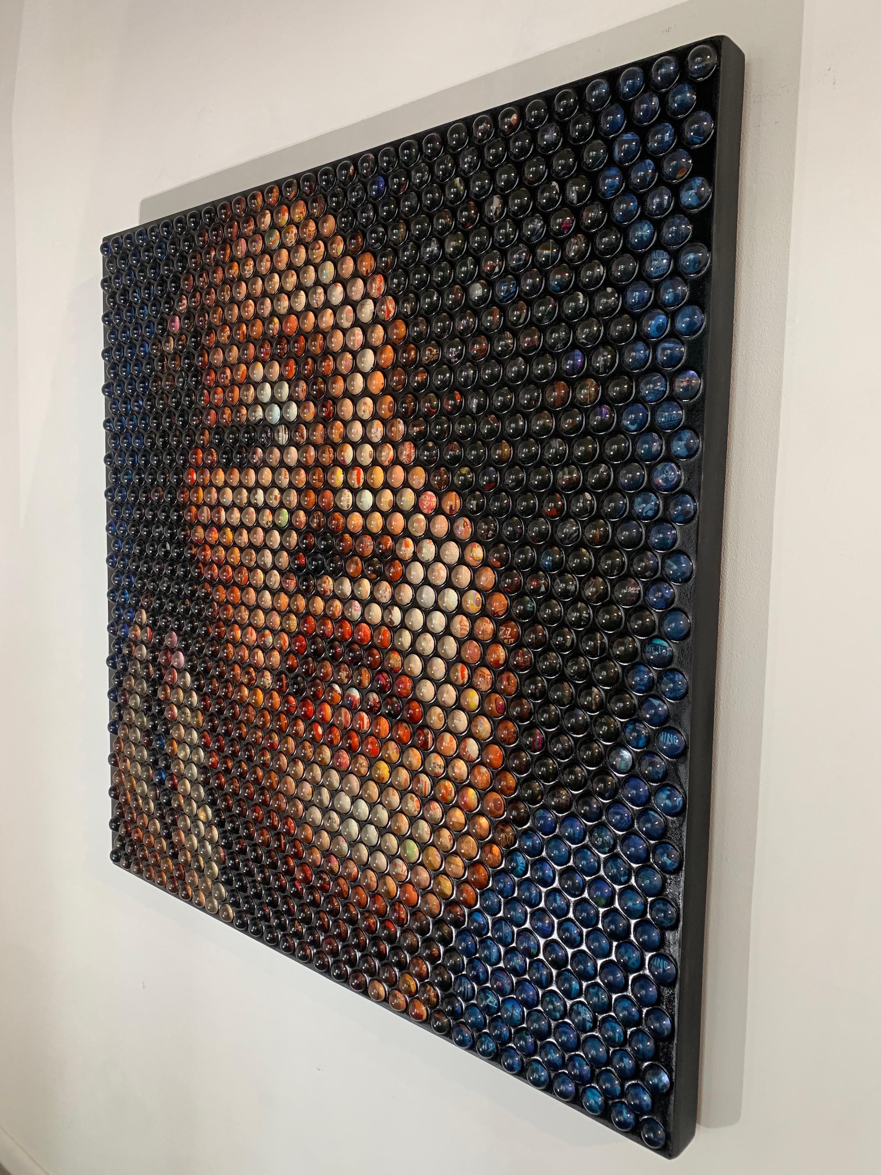 Sphères de verre sur bois 

Des sphères de verre uniques sont disposées pour créer le portrait dynamique d'une jeune femme. Les sphères en verre contiennent des images d'astronautes et de médias liés à l'espace, créant ainsi une composition à
