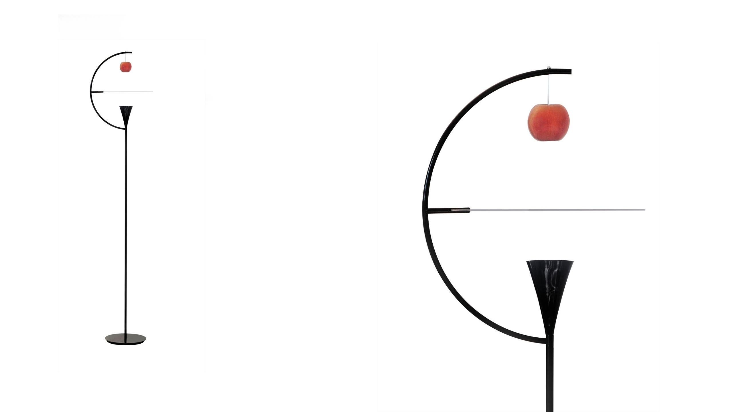 Floor LED lamp with structure in chrome metal or glossy black lacquered and white painted aluminum diffuser. The diffuser rotates and illuminates the natural element, in a mixture of direct and diffused light. A high performance LED source has been