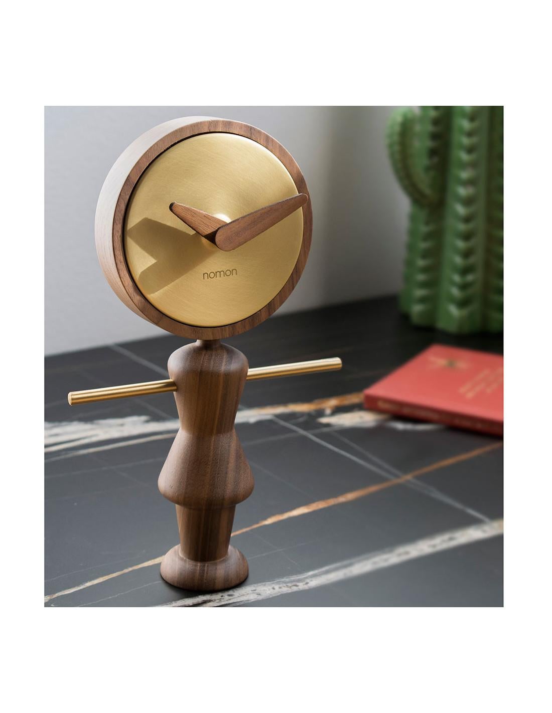  Friendly and fun clocks ideal as a gift to decorate the living room, kitchen or a modern office. Nene G table clock with body and hands in oak or walnut wood and polished brass.
Nene G table clock : Box in polished brass, hands and body in walnut