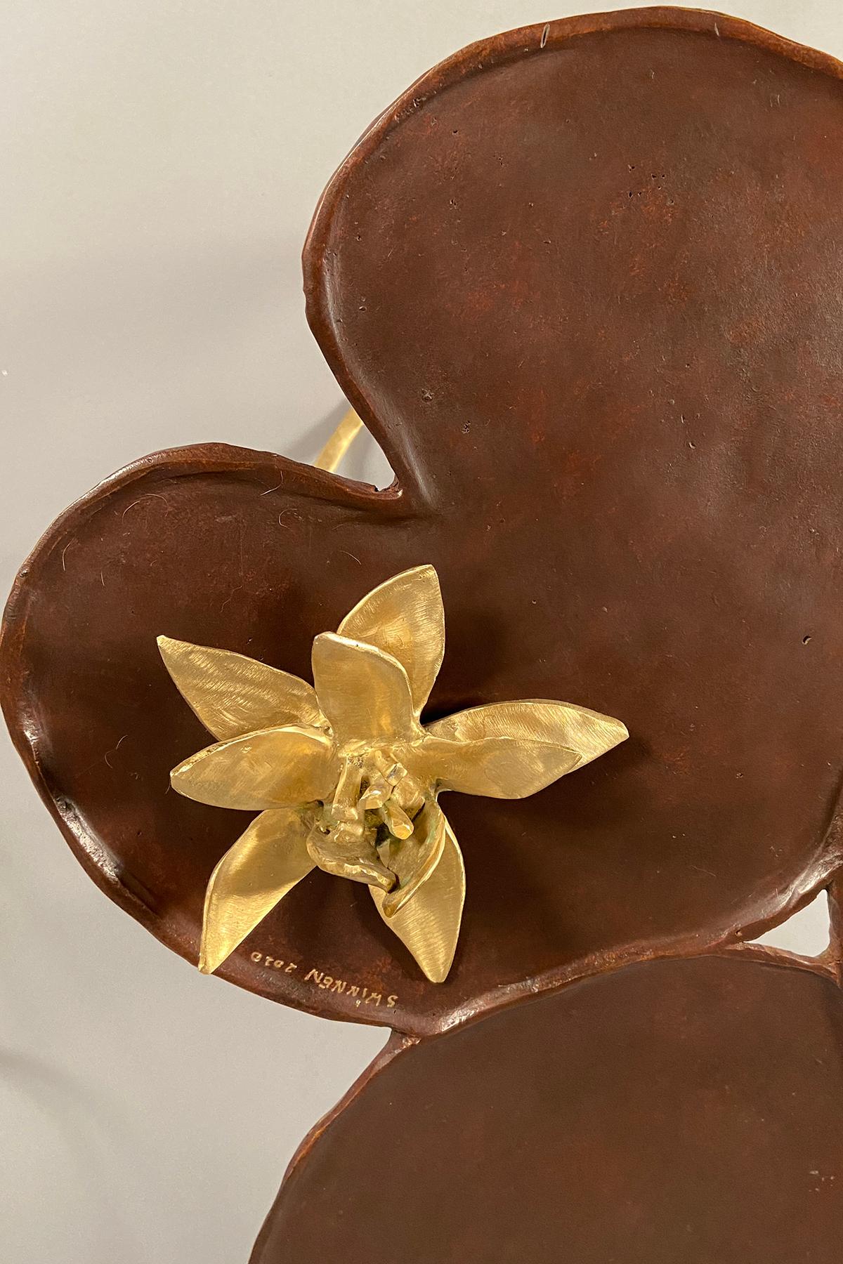 Sculptural side table in the shape of a lily pad (nenuphar) with a brown patina, raised on three polished bronze feet. The table comes with a loose bronze flower.
   