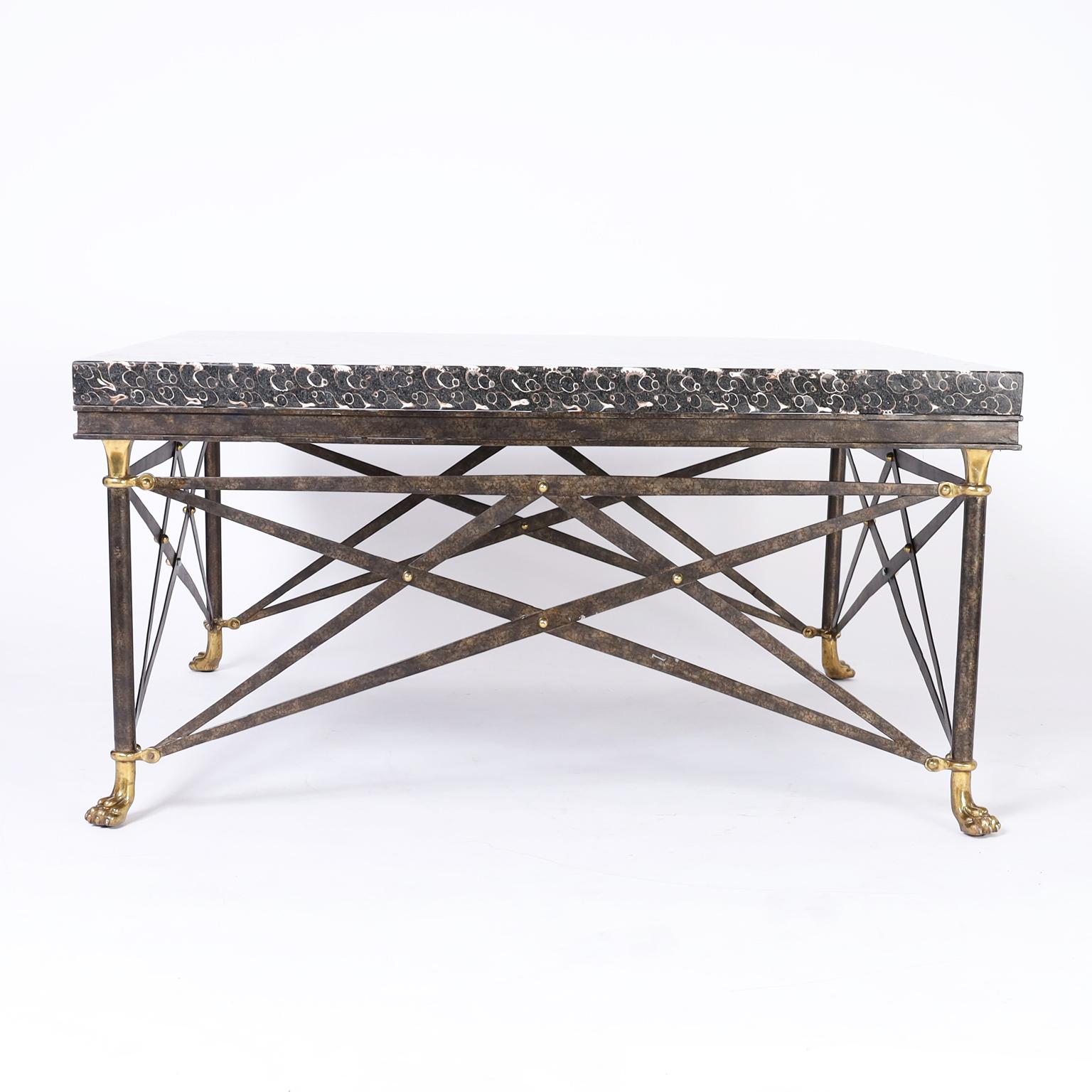 Mid-century coffee table with a square form featuring a terrazzo top with embedded seashells, neo classic base with raw metal and brass highlights and brass paw feet. Signed Maitland-Smith on the bottom.