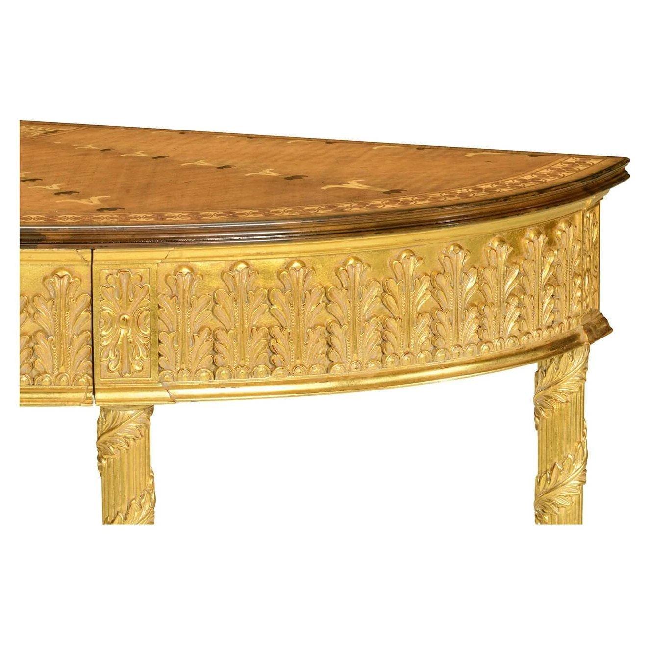 George III Adam neoclassical demilune console table with fine gilded acanthus leaves to the drawer and running up the legs, and a satinwood marquetry top inlaid with floral motifs. After an original of circa 1780.

Dimensions: 46.37