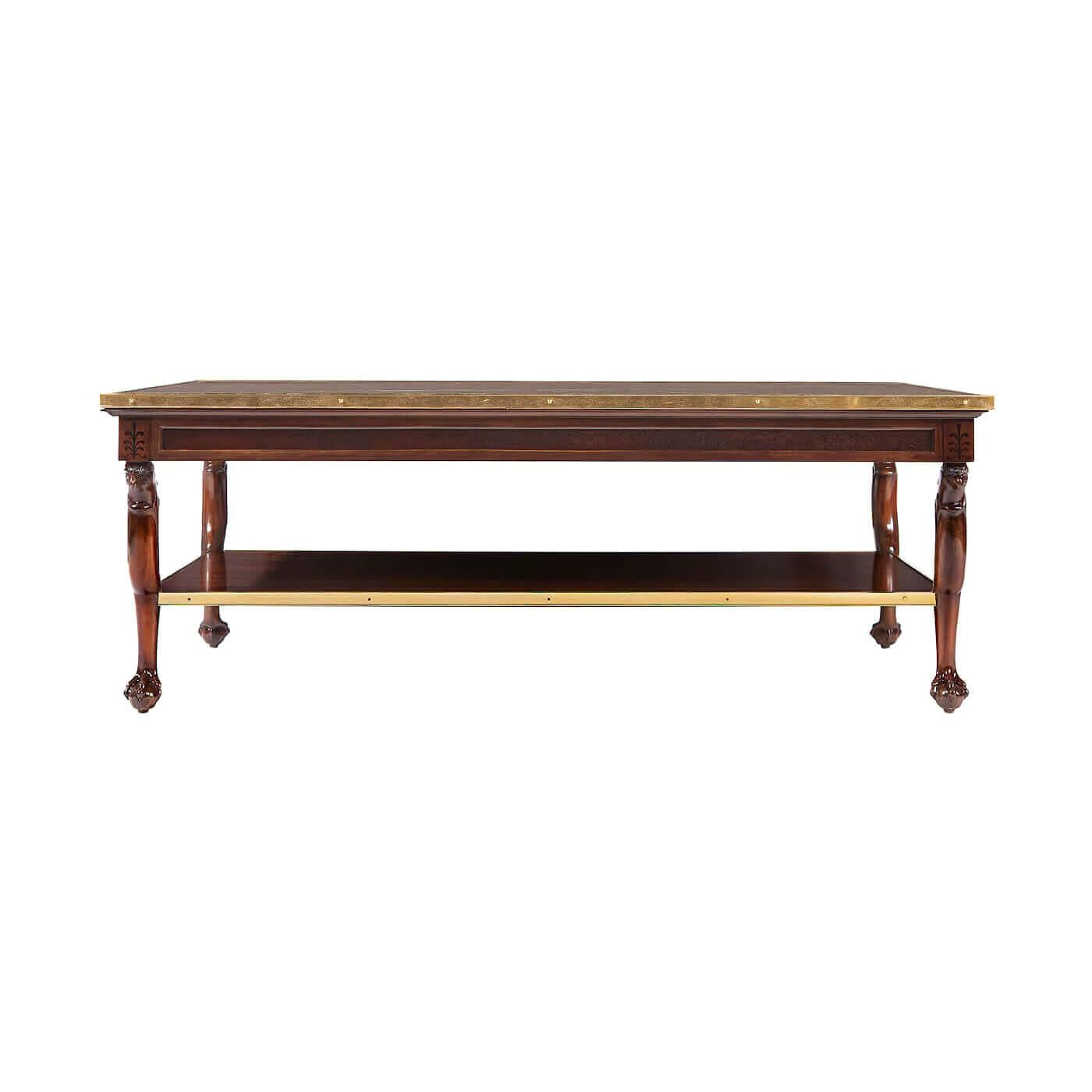 A Neo-Classic style marble top coffee table with inset ebonized paterae decorations. This rectangular table has a marble top and a lower wood shelf with brass galleries, carved griffin head legs, and paw feet. Inspired by an early 19th-century