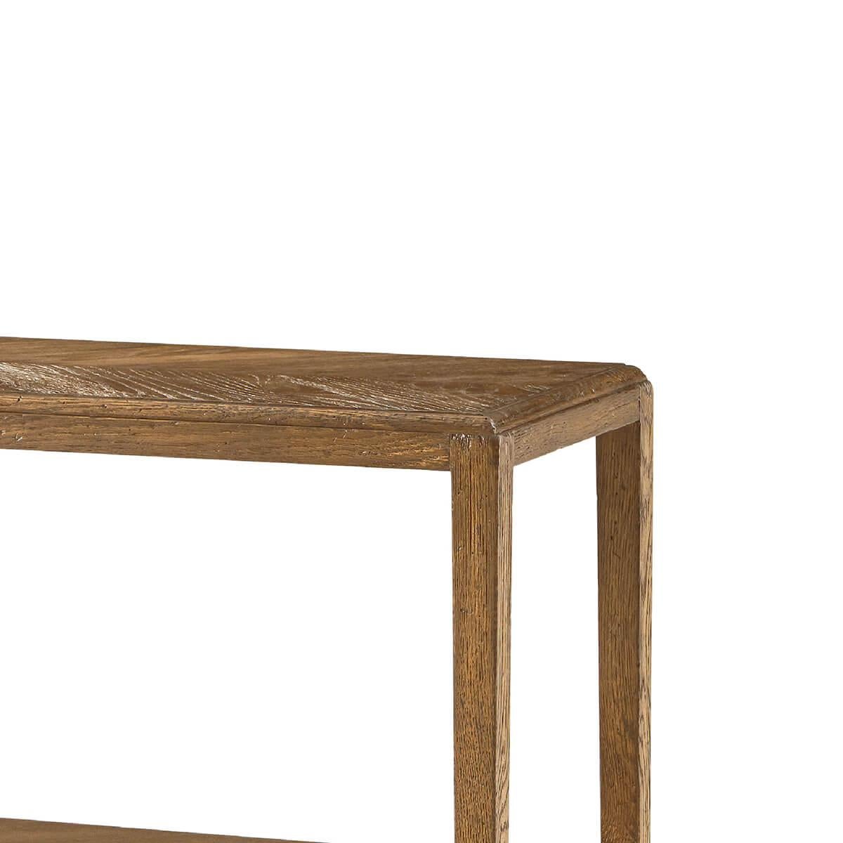 A Neo-Classic style oak three-tier console table with a rectangular mirrored herringbone-patterned oak top and shelves in Dawn finish raised on six tapered oak legs.

Dimensions: 47.5
