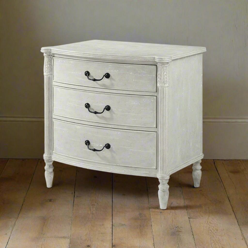 A stunning blend of timeless design and modern craftsmanship. In a Limestone hand-painted finish, the reeded edge bowfront top, with distinctive protruding turret corners, adds architectural elegance, while the acanthus leaf-carved and reeded