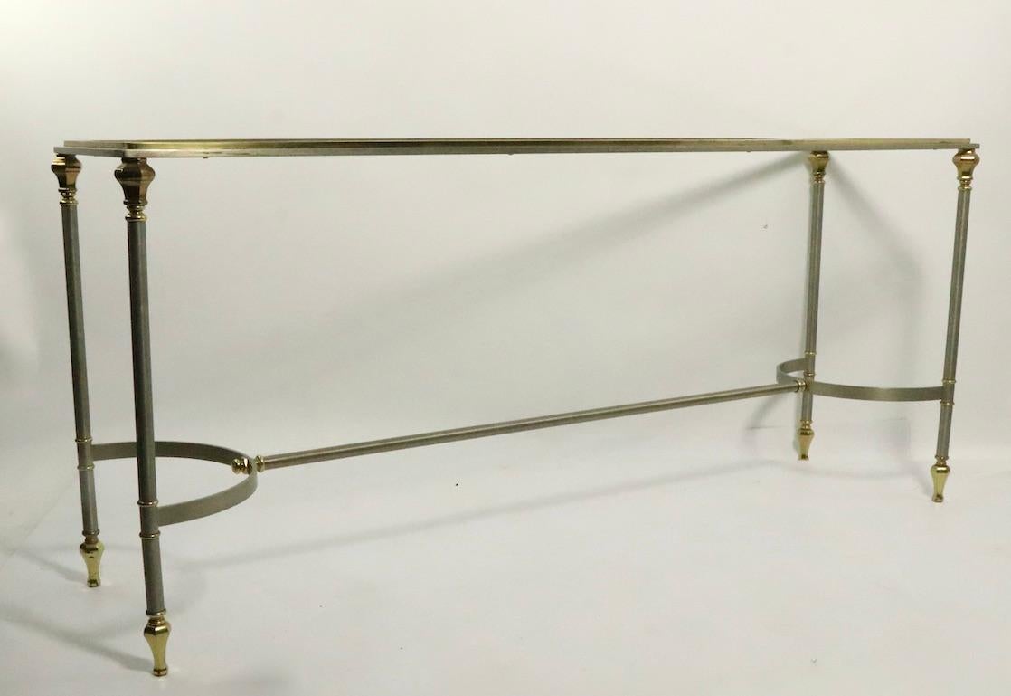 Classical steel and brass console with original plate glass top, probably made in Italy after Maison Jansen. This example is in in very good, original clean and ready to use condition. Unusual to see the console form, this style is usually found as