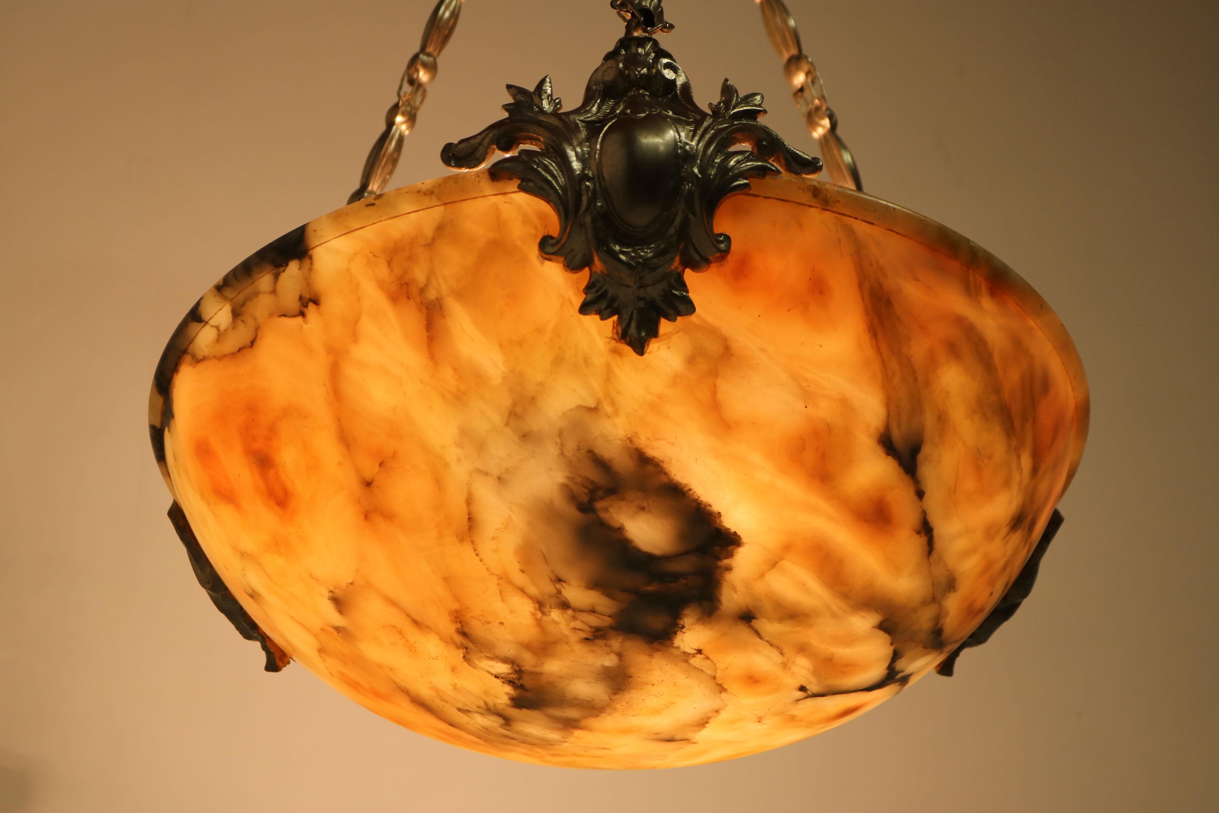 Gorgeous Neoclassical alabaster chandelier / pendant. Fully hand carved alabaster shade with gorgeous colors and grain. 
This chandelier comes straight from France and will leave a lasting impression in any room or hallway. 
The frame is made from
