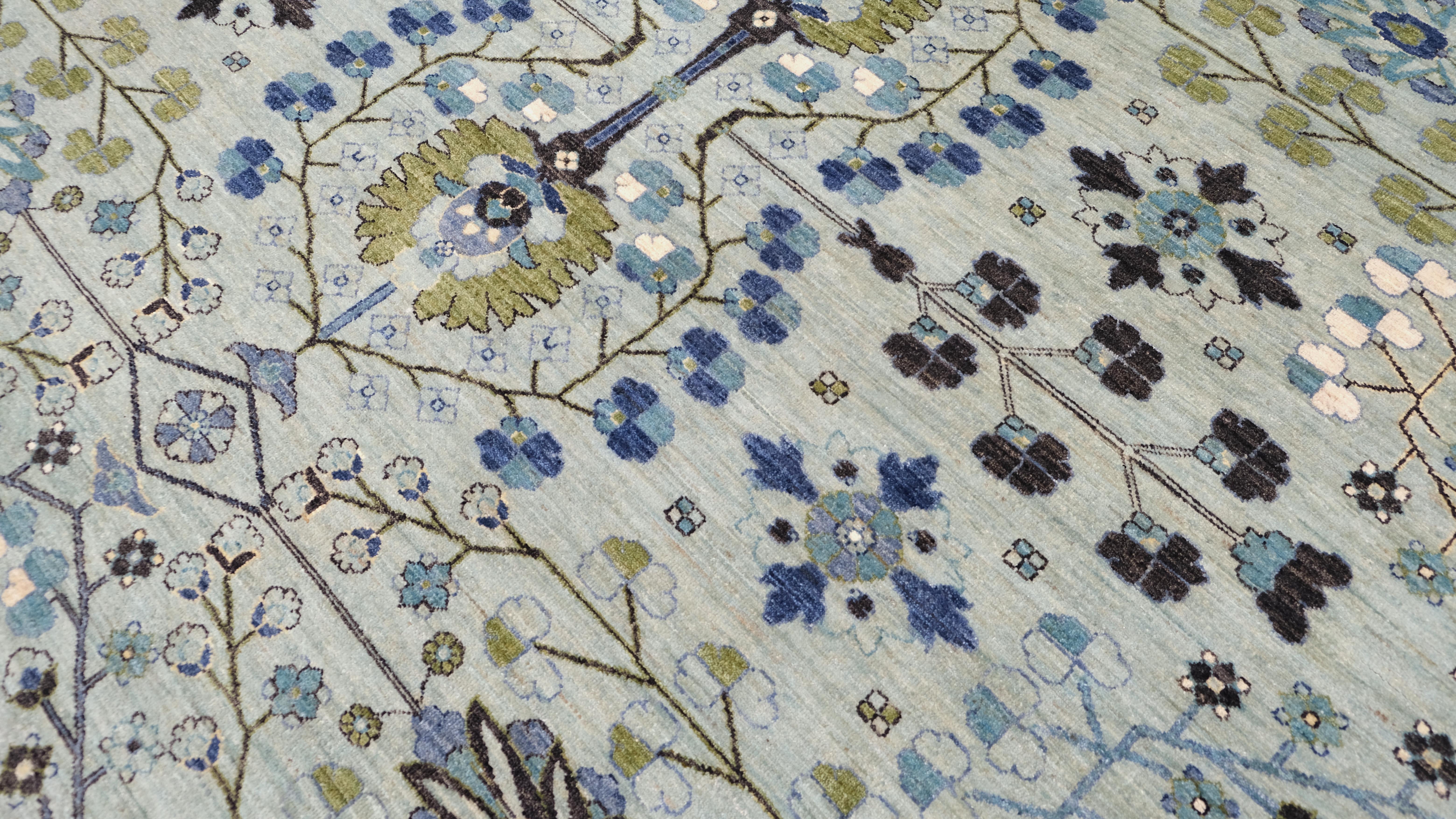 Dieser exquisite, handgeknüpfte Wollteppich von zeigt ein faszinierendes florales und geometrisches Muster, das mit bemerkenswerter Präzision und Kunstfertigkeit gewebt wurde. Das zartgrüne Feld dient als perfekter Hintergrund für die üppigen grünen