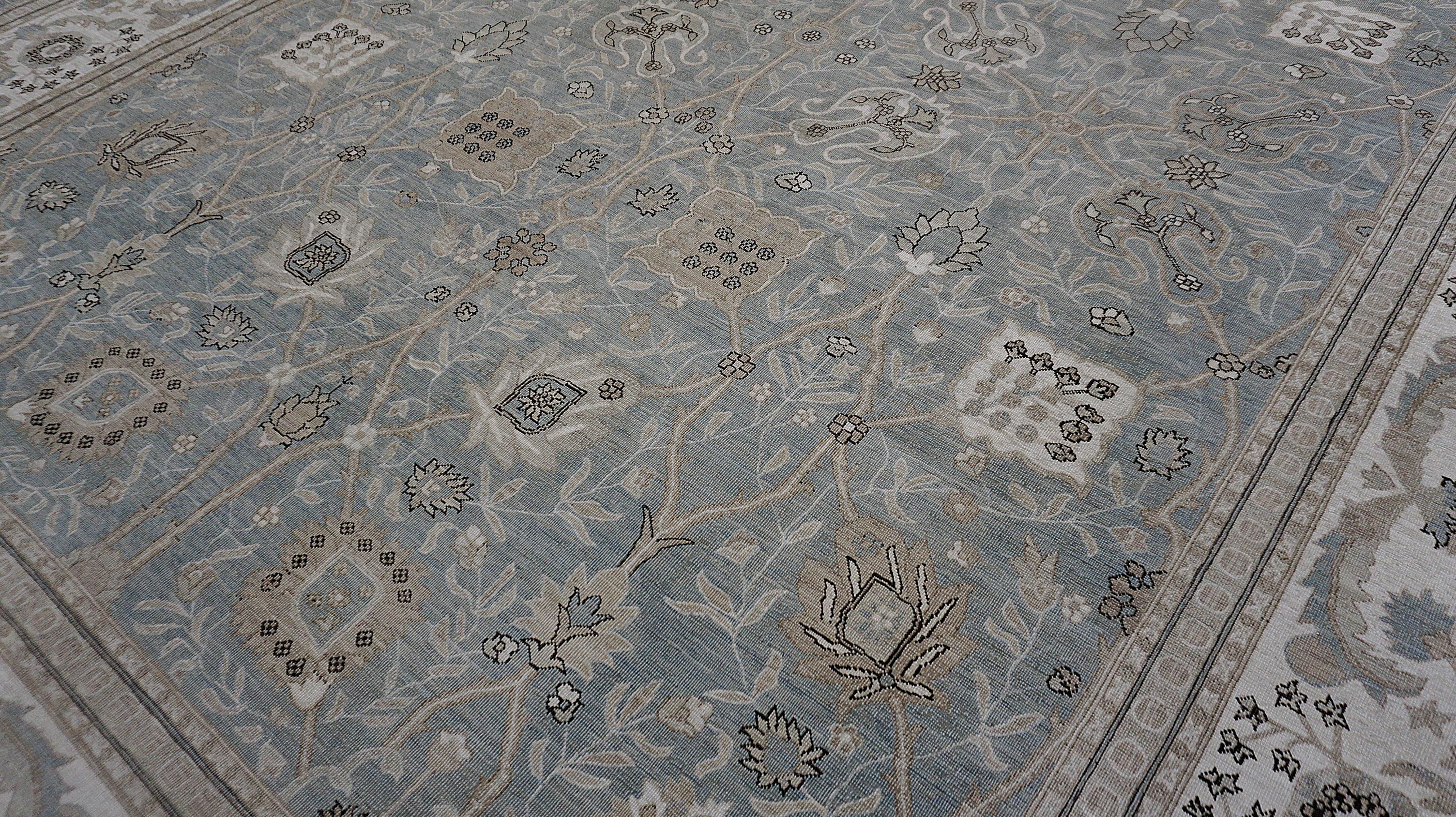 Ce tapis en laine noué à la main présente une interprétation sereine de la tradition Sultanabad, célébrée pour ses motifs à grande échelle et ses compositions spacieuses. Rendu dans un champ bleu-gris apaisant avec des nuances douces de vert et