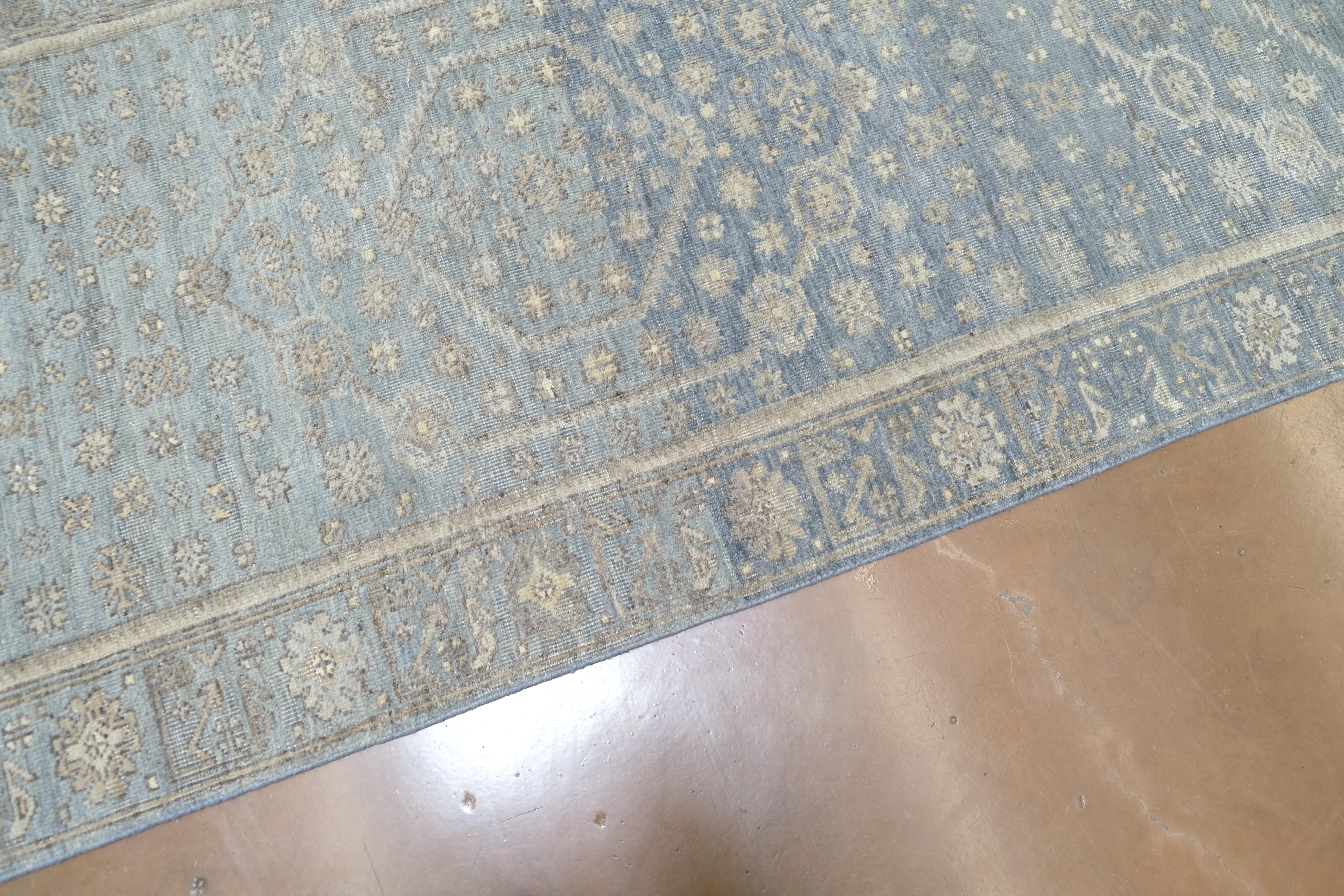 Dieser exquisite, handgeknüpfte Woll-Läufer ist eine raffinierte Interpretation des klassischen Oushak-Stils, neu interpretiert in einer beige-blauen Farbpalette. Dieses Stück wird mit traditionellen Knüpftechniken und hochwertiger, handgesponnener