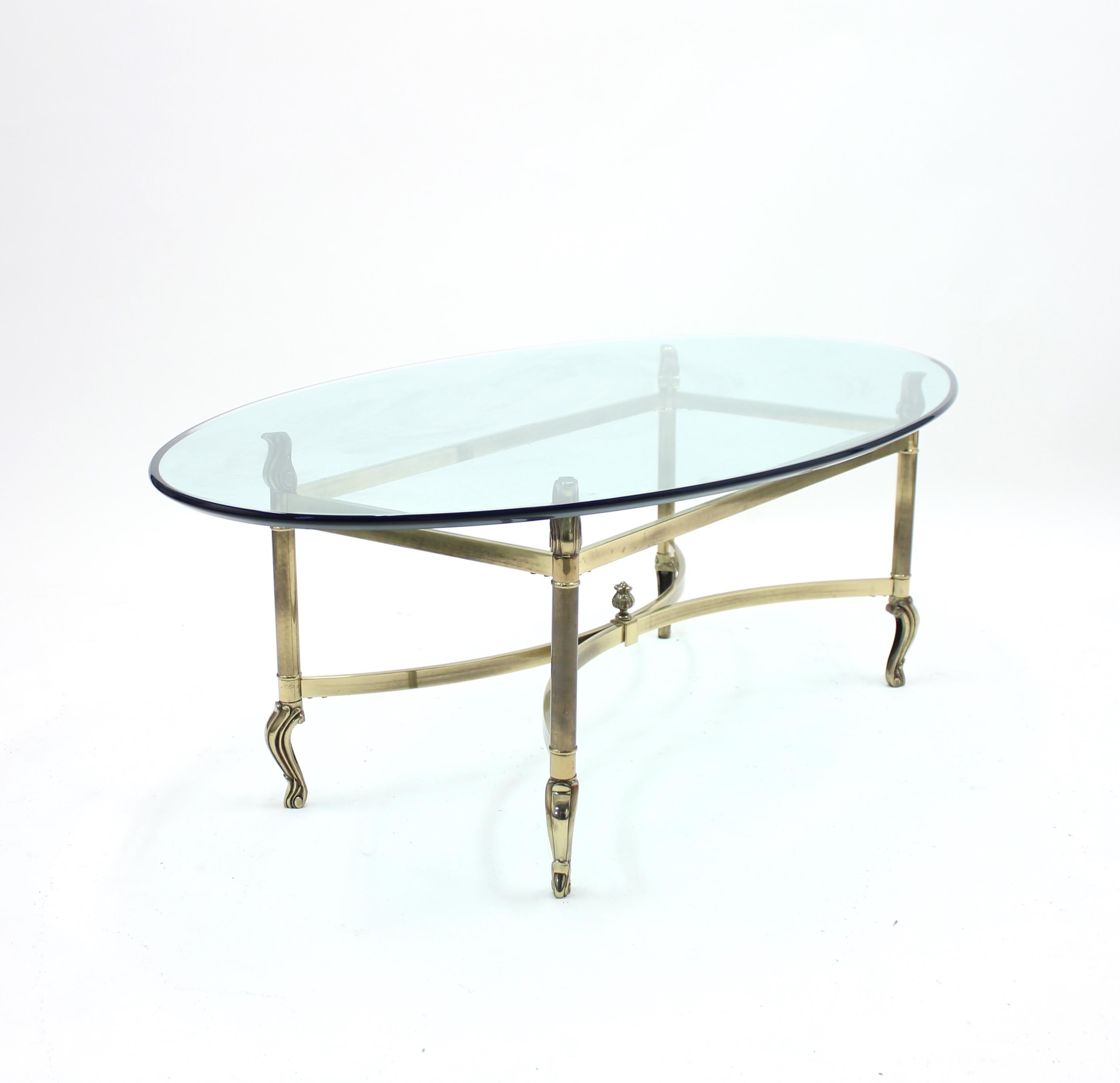 1980s oval brass table in a neoclassical style with detailed ornaments. Good vintage condition with ware consistent with age and use.
  