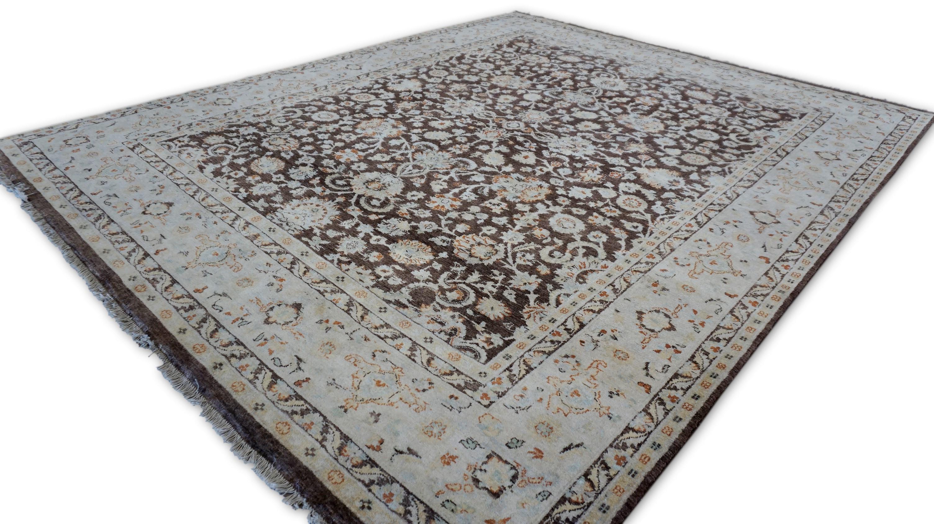 Ce tapis en laine Tabriz Pattern noué à la main offre une réinterprétation sophistiquée des motifs floraux persans traditionnels avec une touche audacieuse et moderne. Réalisé avec élégance, le tapis présente un opulent champ brun espresso densément