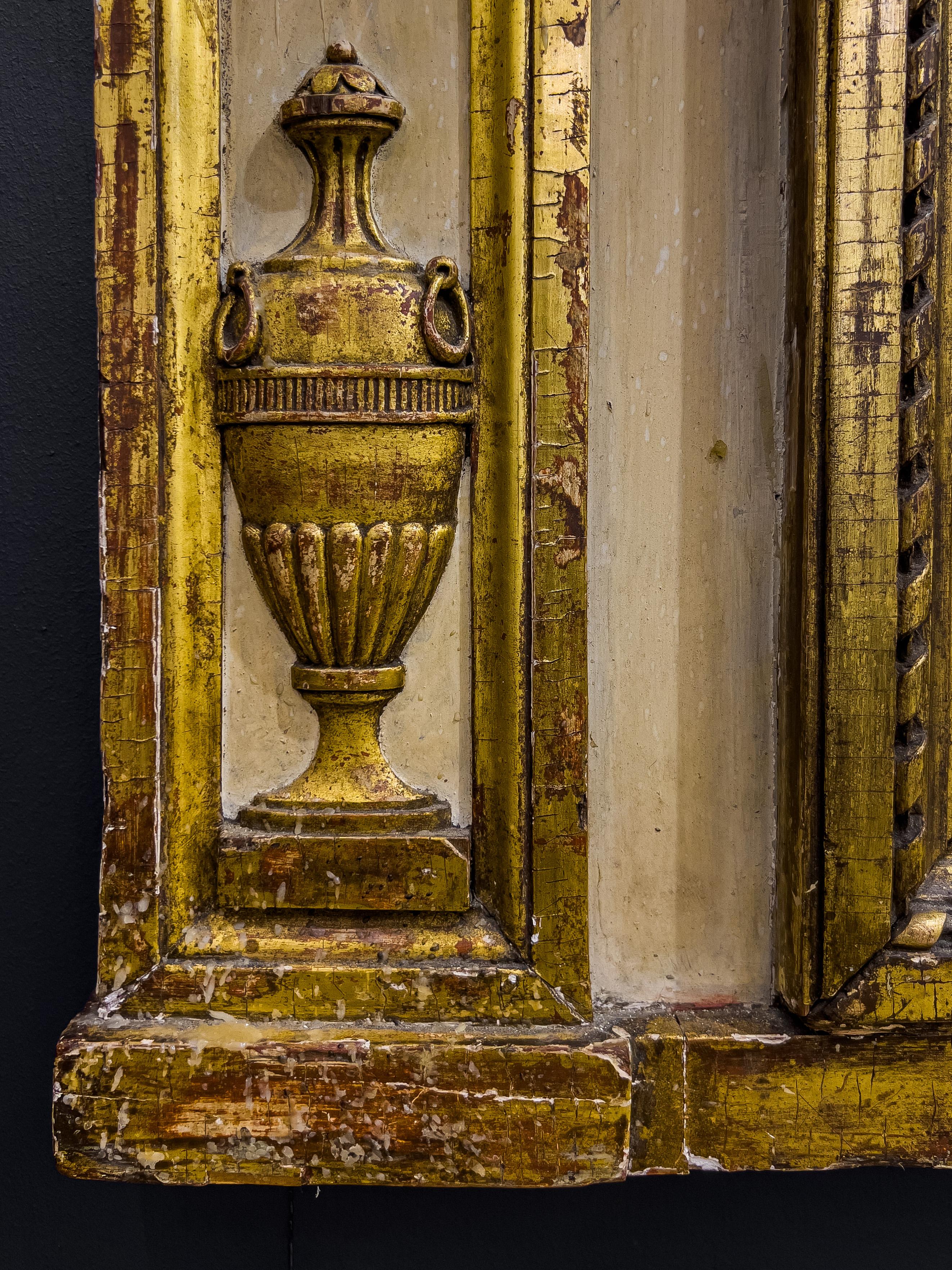Miroir de cheminée néoclassique sculpté, peint et doré à la Parcel, datant du 19e C. Le miroir est en deux parties et la sculpture représente une guirlande de rosettes et d'urnes.