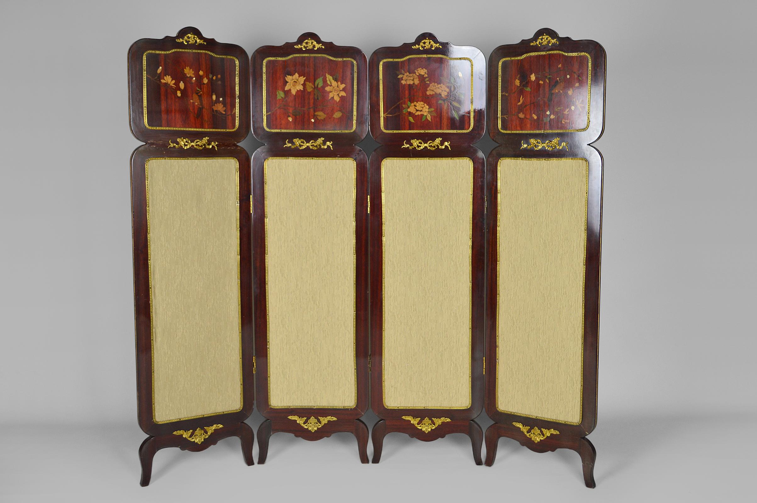 Wooden 4-panel folding screen with marquetry.

The upper part is decorated with Japanese-inspired marquetry of various species. The fabric of the lower part has been changed recently, it is in good condition. 
The panels are enhanced with sticks