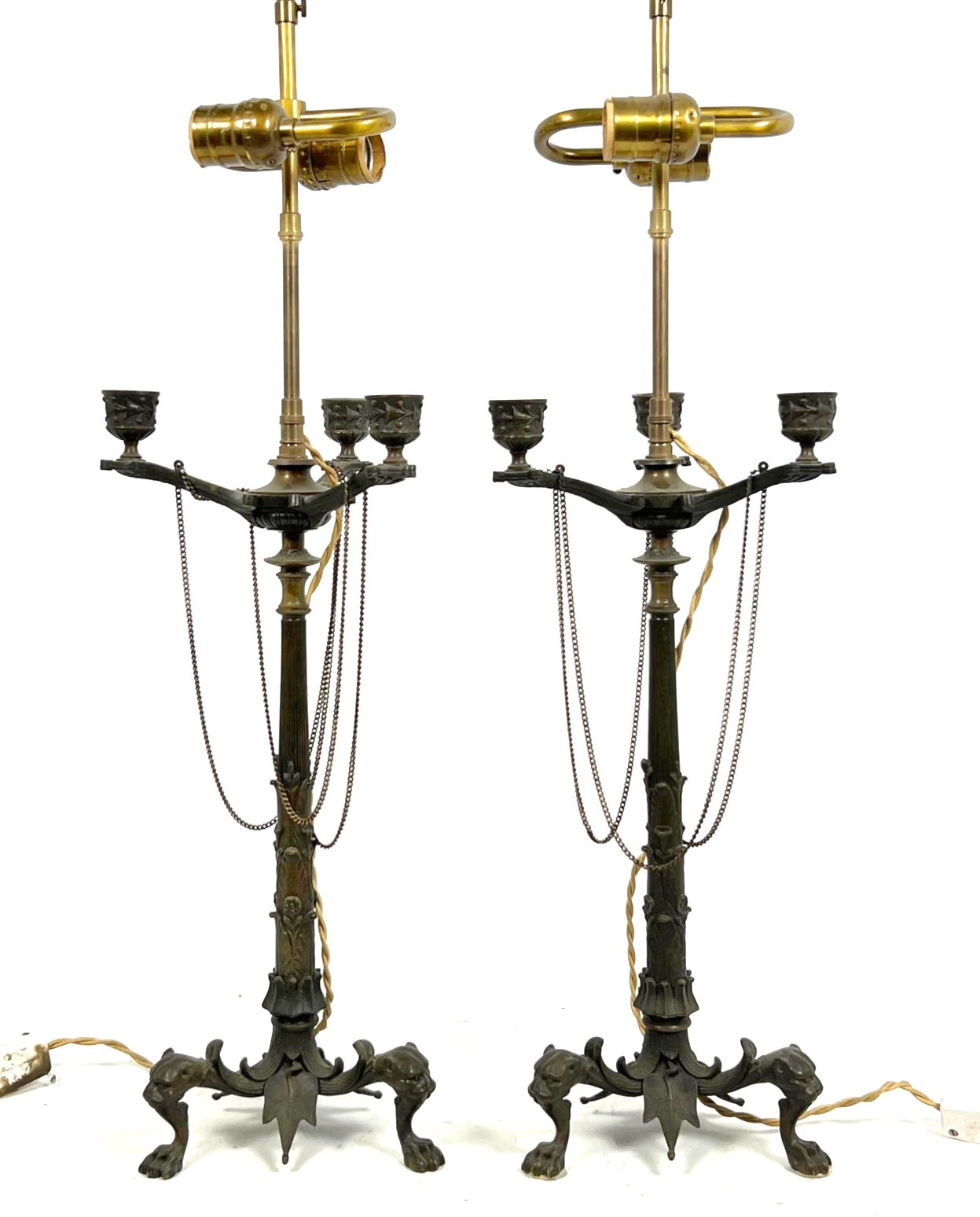 A beautiful well cast and finished pair of late 19th/Early 20th Century Candelabra turned into lamps. These Grand Tour souvenirs are solid cast bronze with lion head and paw feet.  Nice shield sand snake decor around the bottoms. These were wire