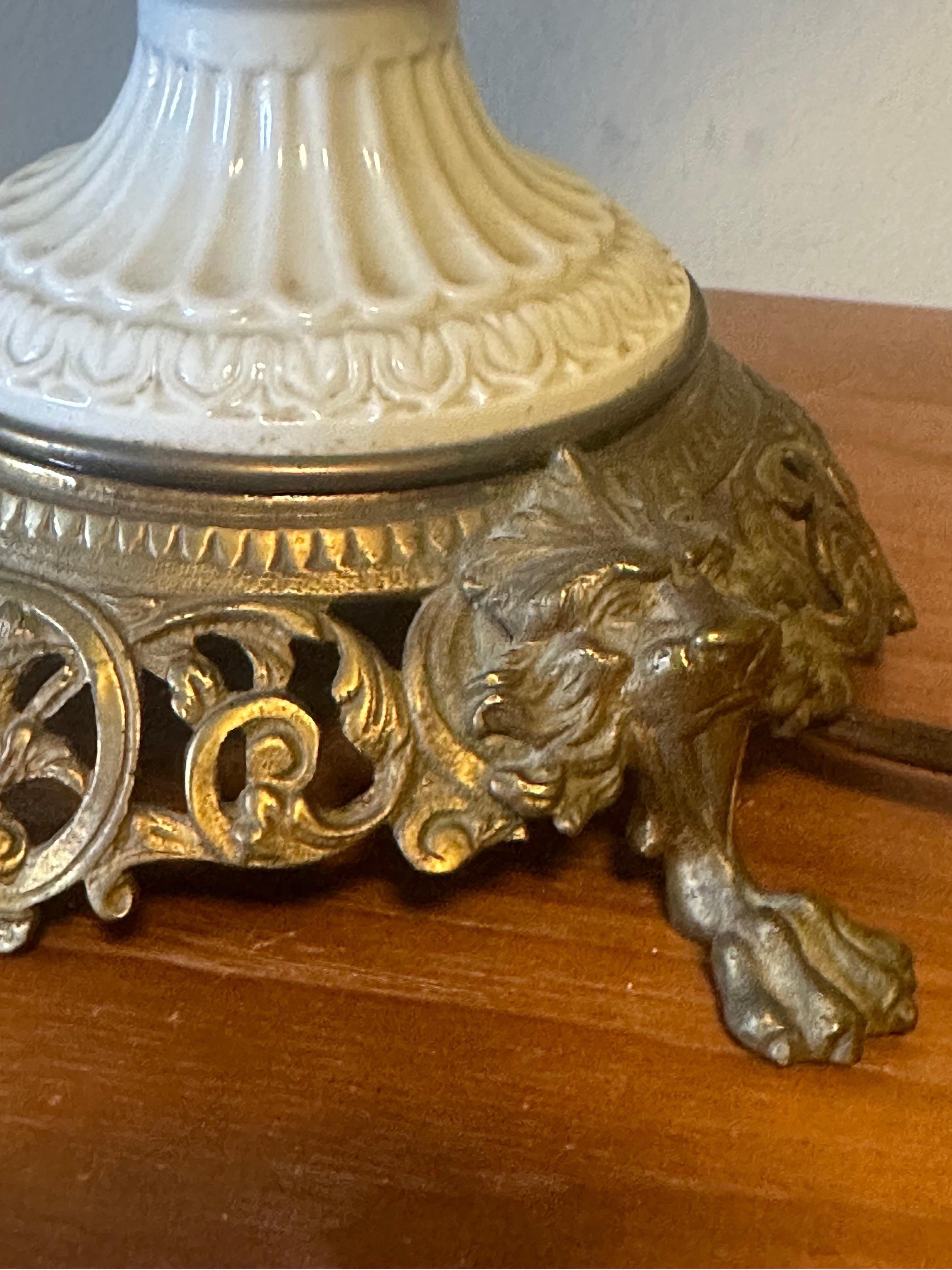 Exceptionally detailed down to the scales of the serpents, minimalist in its blanc-de-chine glaze, the details of snakes and neo classical ornamentation create a clever sleekness in its charm. Placed on an ornate brass lion and paw base. A wonderful