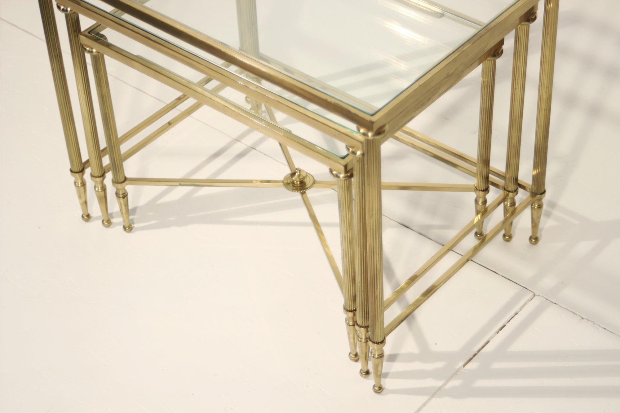 20th Century Neo-classical nesting tables in gilded brass & glass by Maison Jansen, France  For Sale
