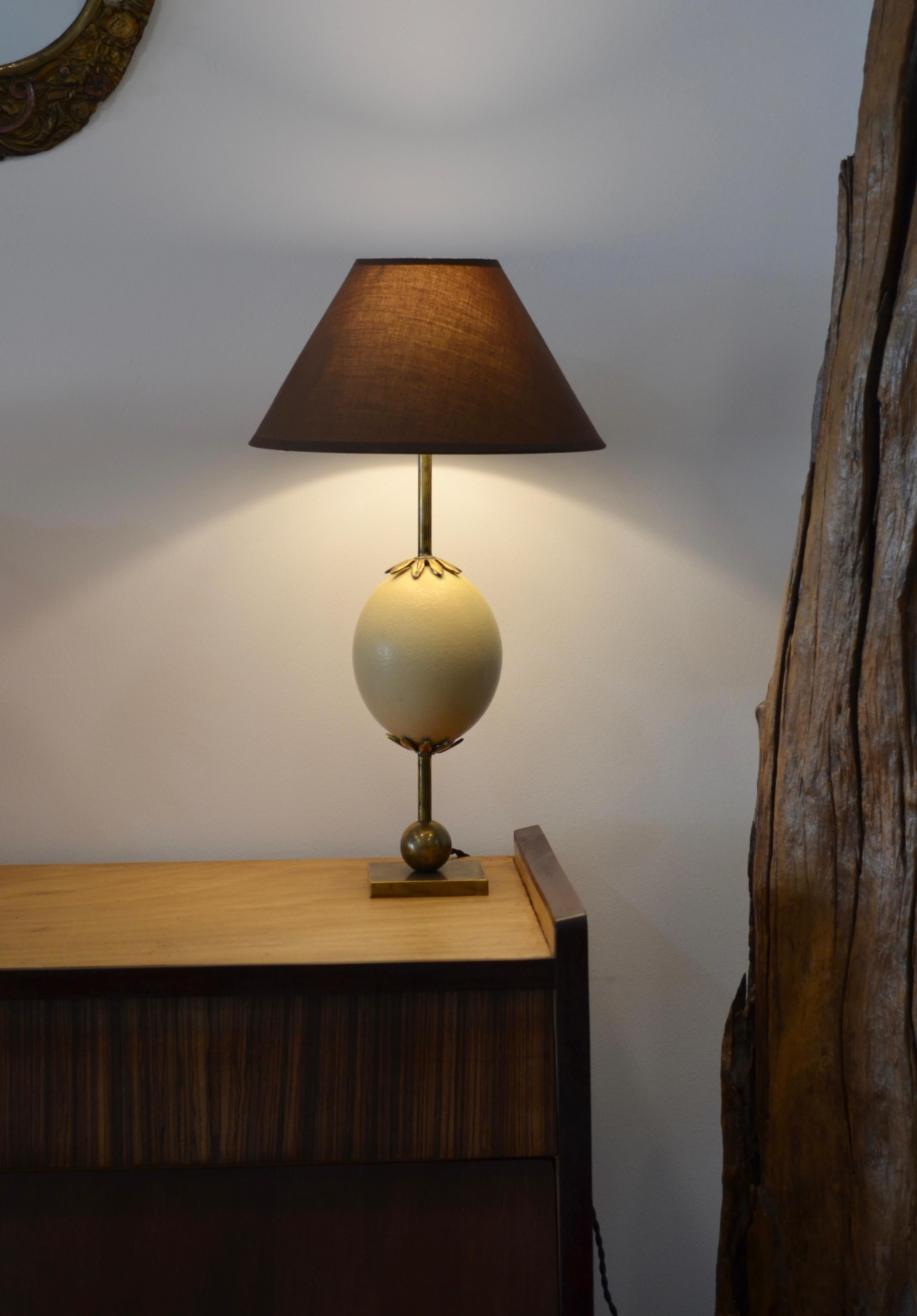 Elegant brass lamp composed of an ostrich egg topped with a bronze collar
some shades of white on the egg.
For sale without lampshade