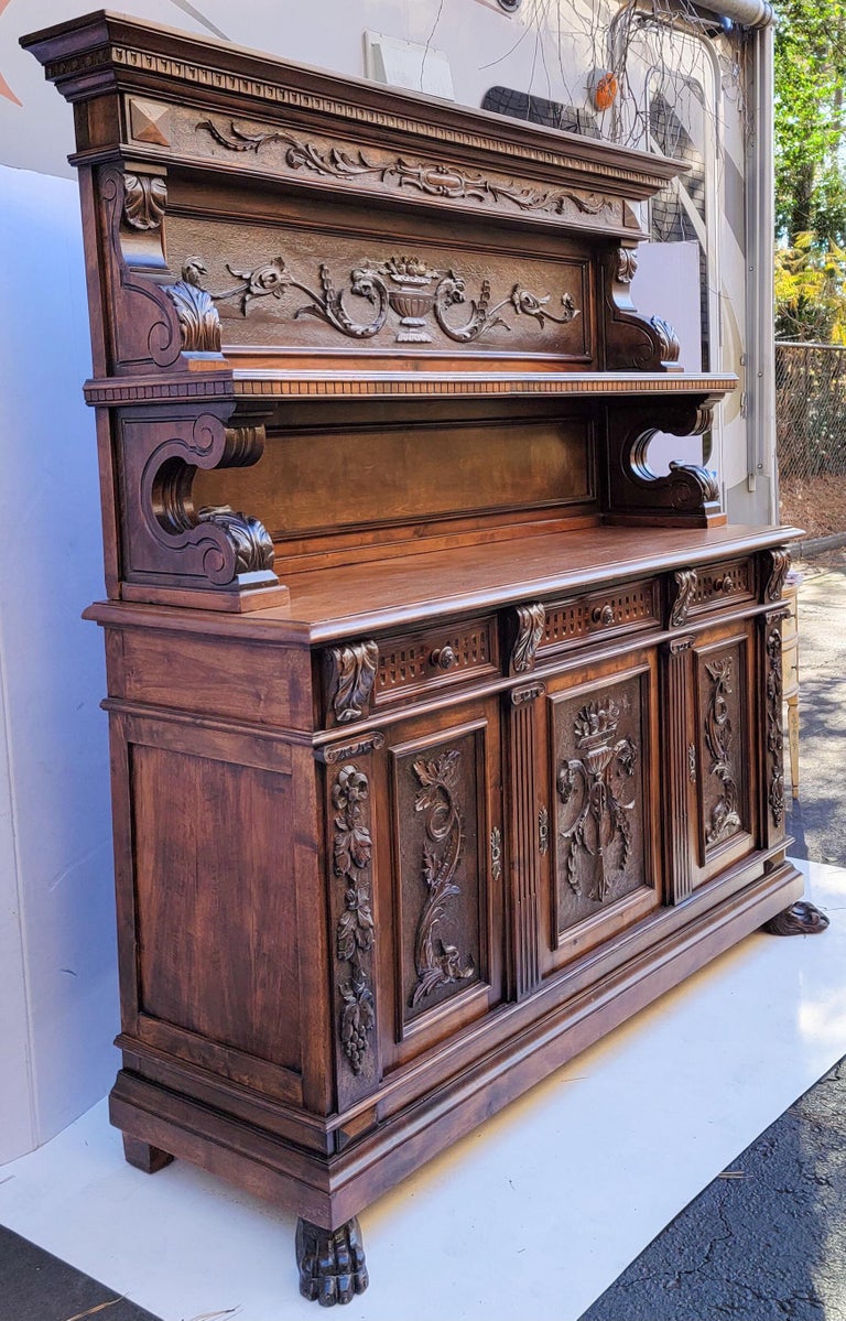This is a show stopper! This is a Neo-Classical Revival carved walnut Italian cabinet dating to approximately 1880. It is two pieces, three drawers over two doors, and it does have the key. Note the hand carved floral foliate that runs across the