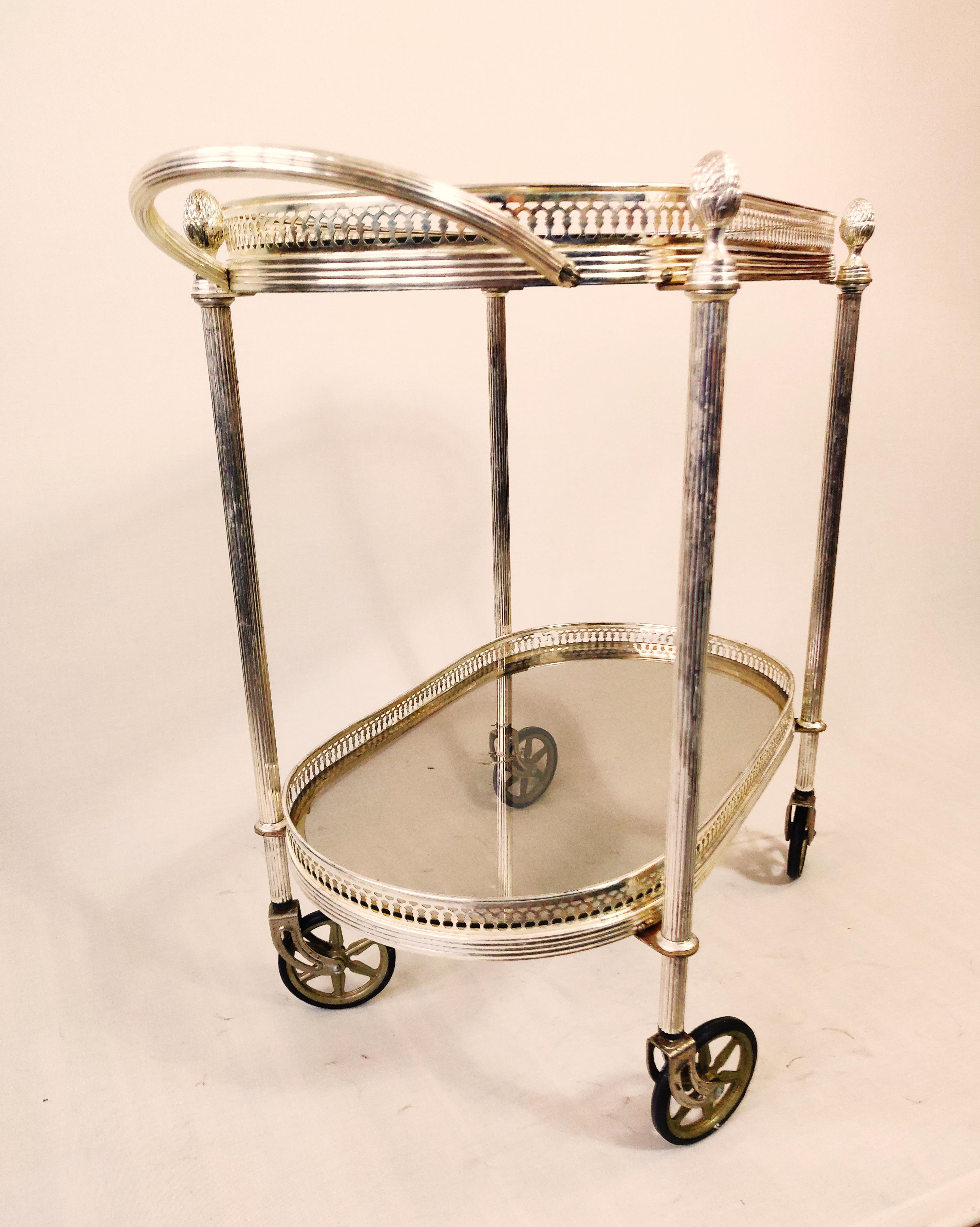 Silvered neoclassical bar cart in style of Maison Jansen,
 Very attractive Maison Jansen style silvered bronze 2 tier bar cart. Finely cast galleries give this piece a neoclassical flair. All original wheels which run smoothly.
It features two oval