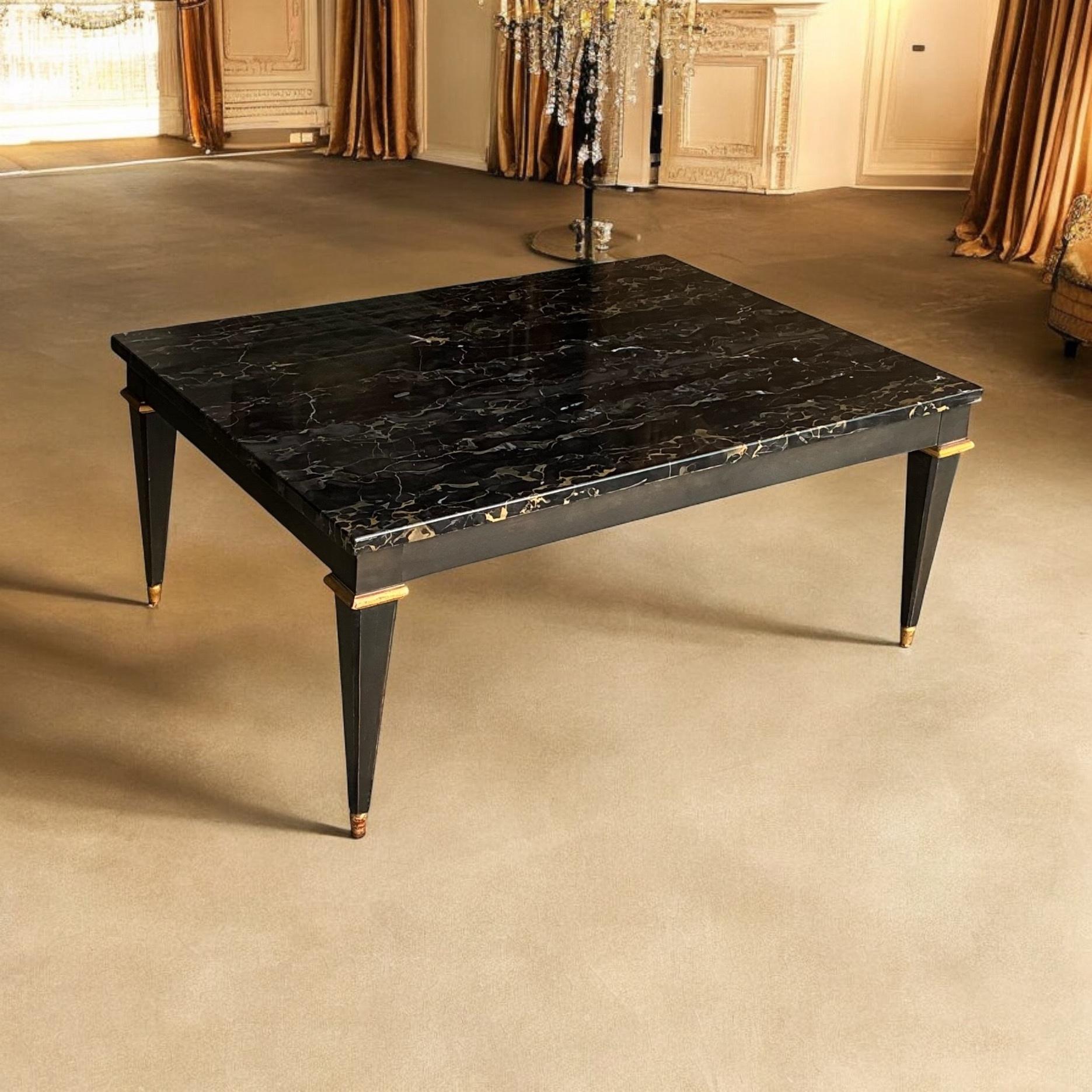 This is a 1970s neo-classical style coffee table by Baker Furniture. It has an Italian marble top and ebonized base with gilt accents. It is marked and in very good condition.

Shipping is running 2 to 5 weeks. If your destination involves a ferry,