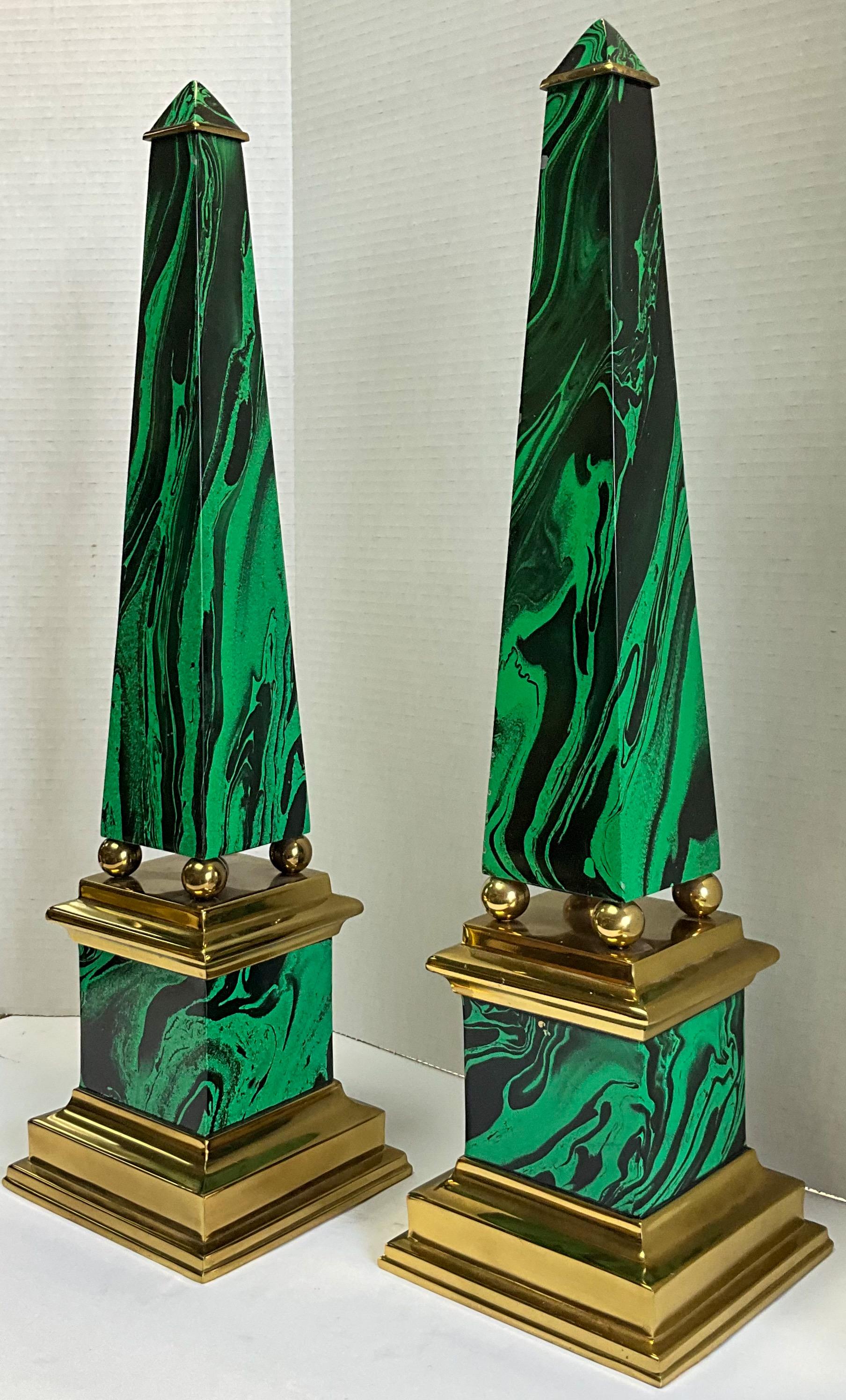 This is a late 20th century pair of Neo-classical style faux malachite brass obelisks. They are in very good condition and unmarked. The bottoms are felt lined.